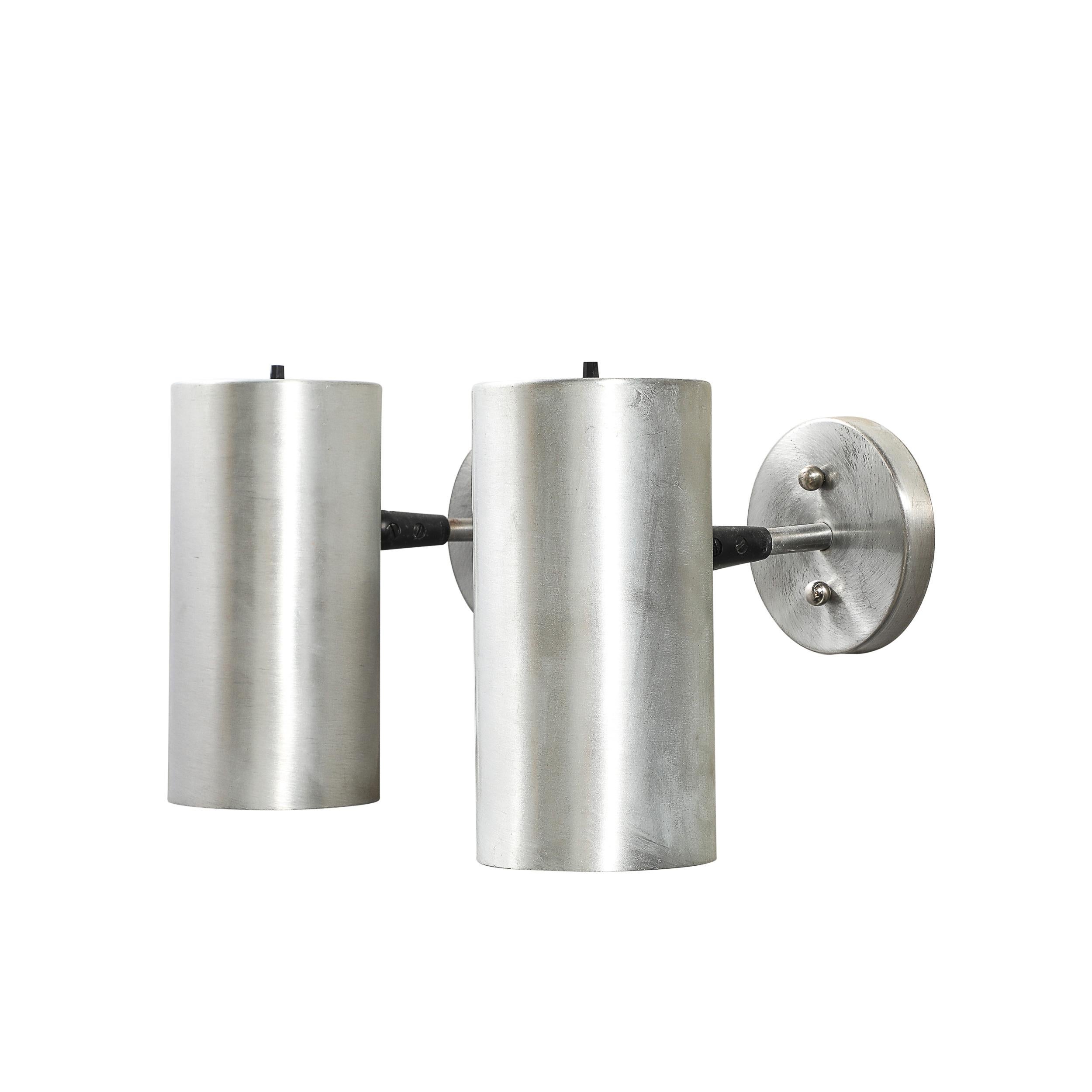 Questa coppia di applique cilindriche del Mid-Century Modernist di Lightolier, realizzata negli anni '70, rappresenta la filosofia del design pulito e minimalista dell'epoca. Combinando forma e funzione, queste appliques rappresentano una