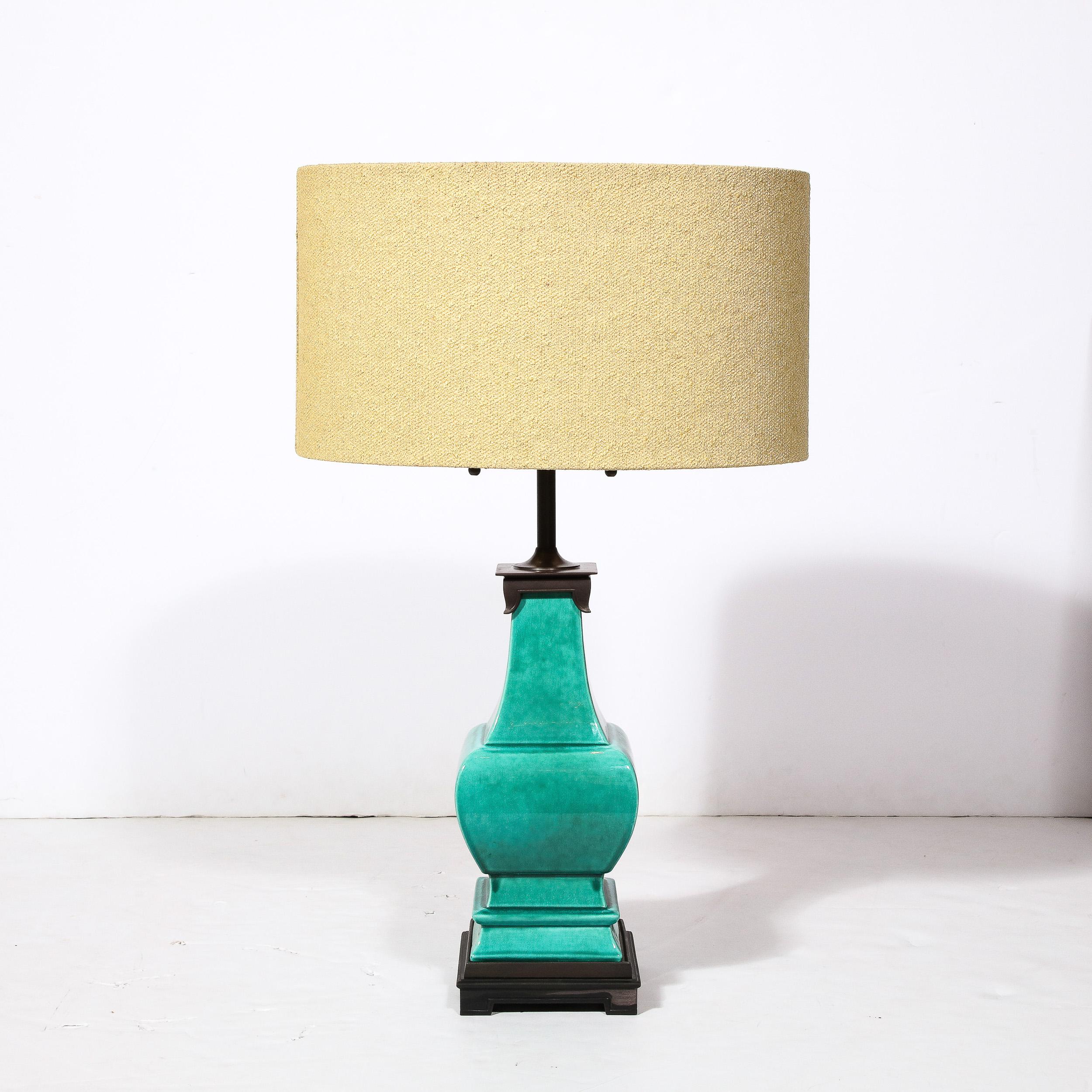 This Pair of Turquoise Jade Table Lamps originate from the United States circa 1960,. In a beautiful and calming hue of green ceramic, these pieces are fitted at the top and bottom of their curved and tiered architectural profile with oil rubbed