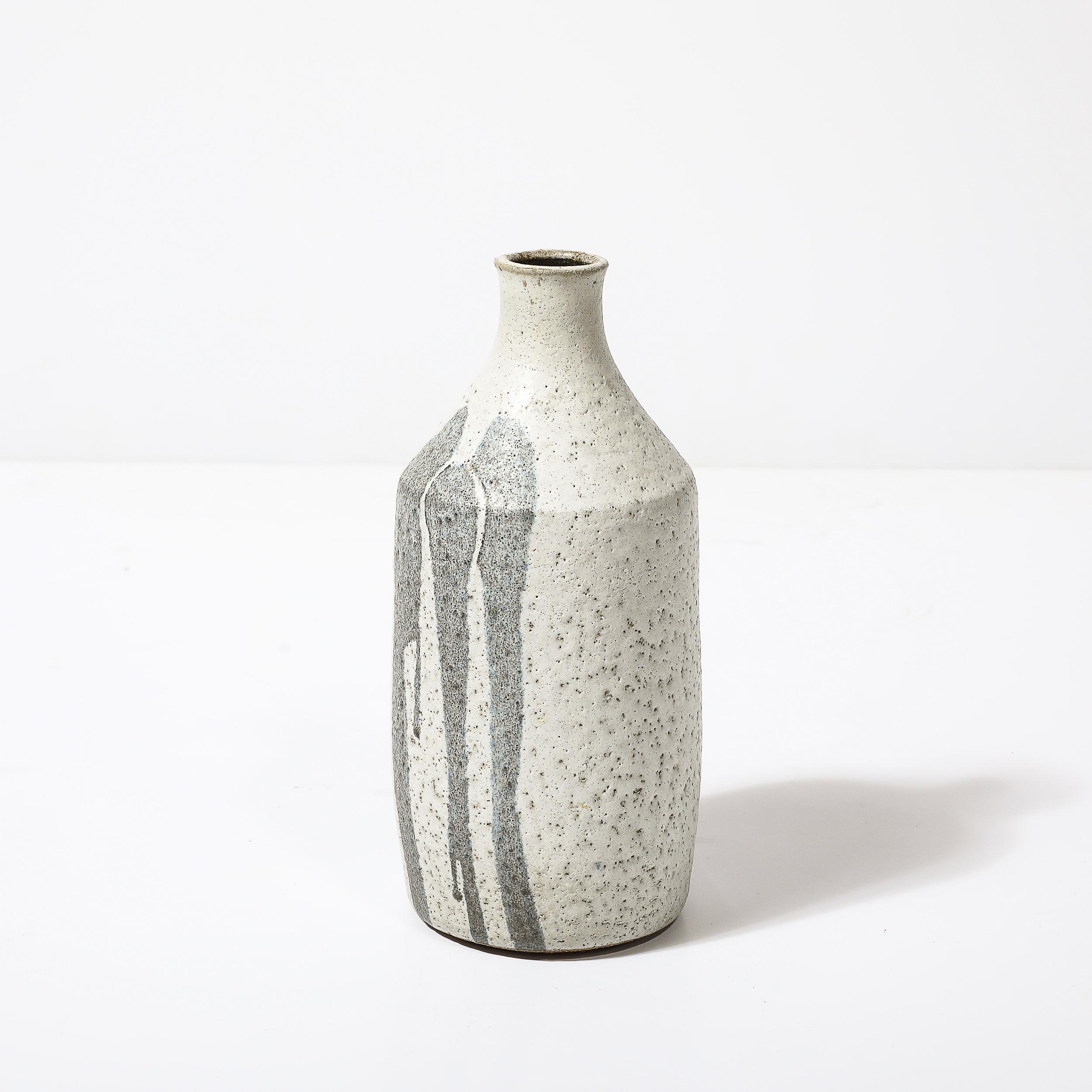 Este precioso y minimalista Jarrón de Cerámica Modernista de Mediados de Siglo en Gris con Detalle de Goteo Azul Silencioso es originario de Estados Unidos, Circa 1960. Presenta un cuerpo sutilmente ahusado con un acabado texturizado esmaltado en