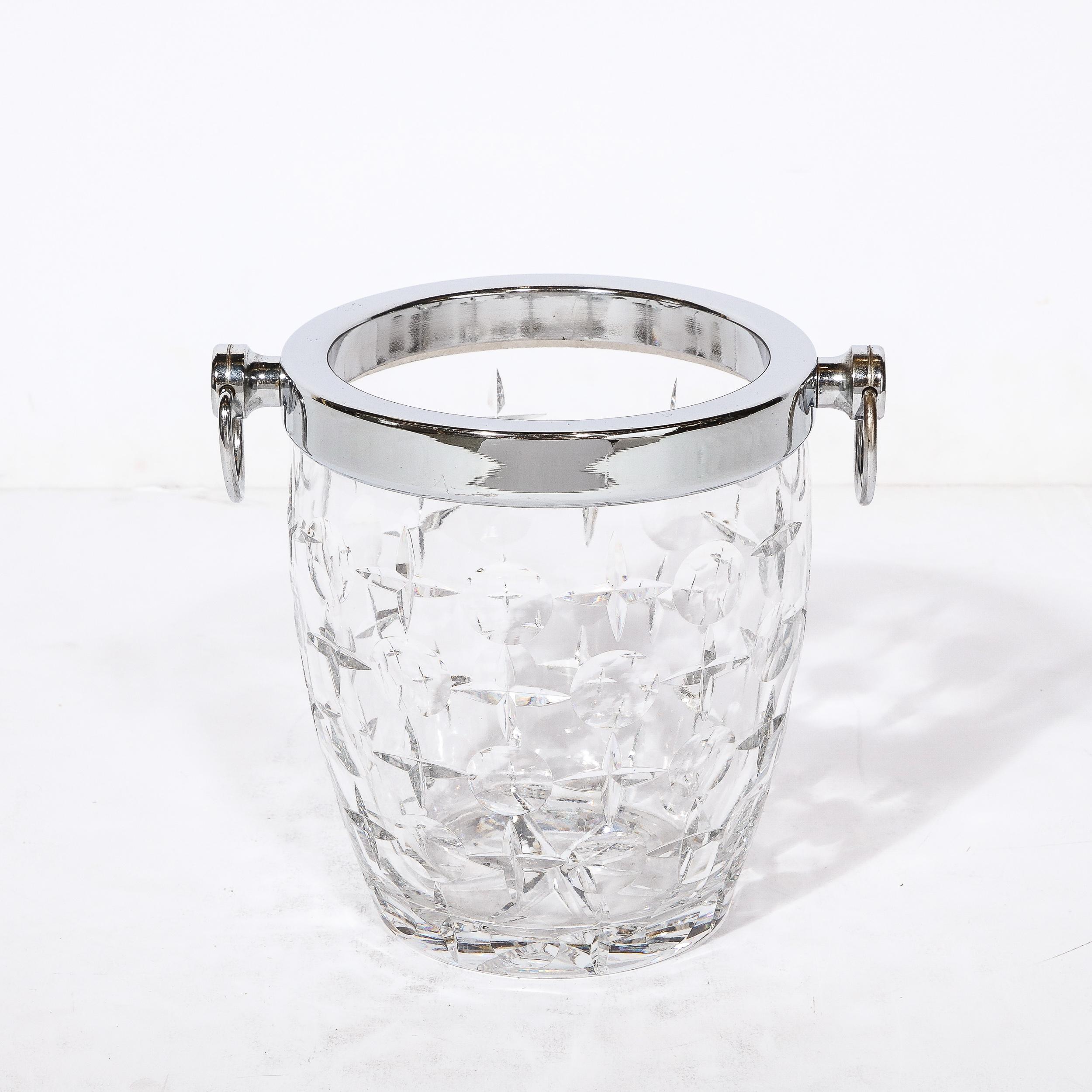 This bold and glamorous Mid-Century Modernist Cut Crystal Ice Bucket Originates from France, Circa 1950. Featuring a rim and handles rendered in polished chrome, the body of the ice bucket is made entirely of Cut Crystal with star form patterning