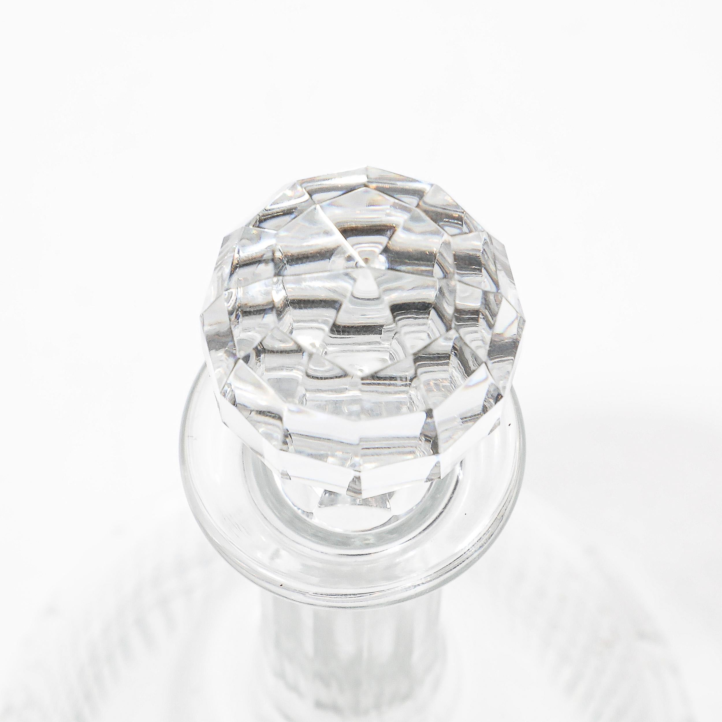 Este decantador de cristal tallado facetado modernista de mediados de siglo, firmado por Baccarat, Francia, es un sorprendente ejemplo de la elegancia del siglo XX. Reconocida por su claridad y calidad, la artesanía de Baccarat brilla en el diseño