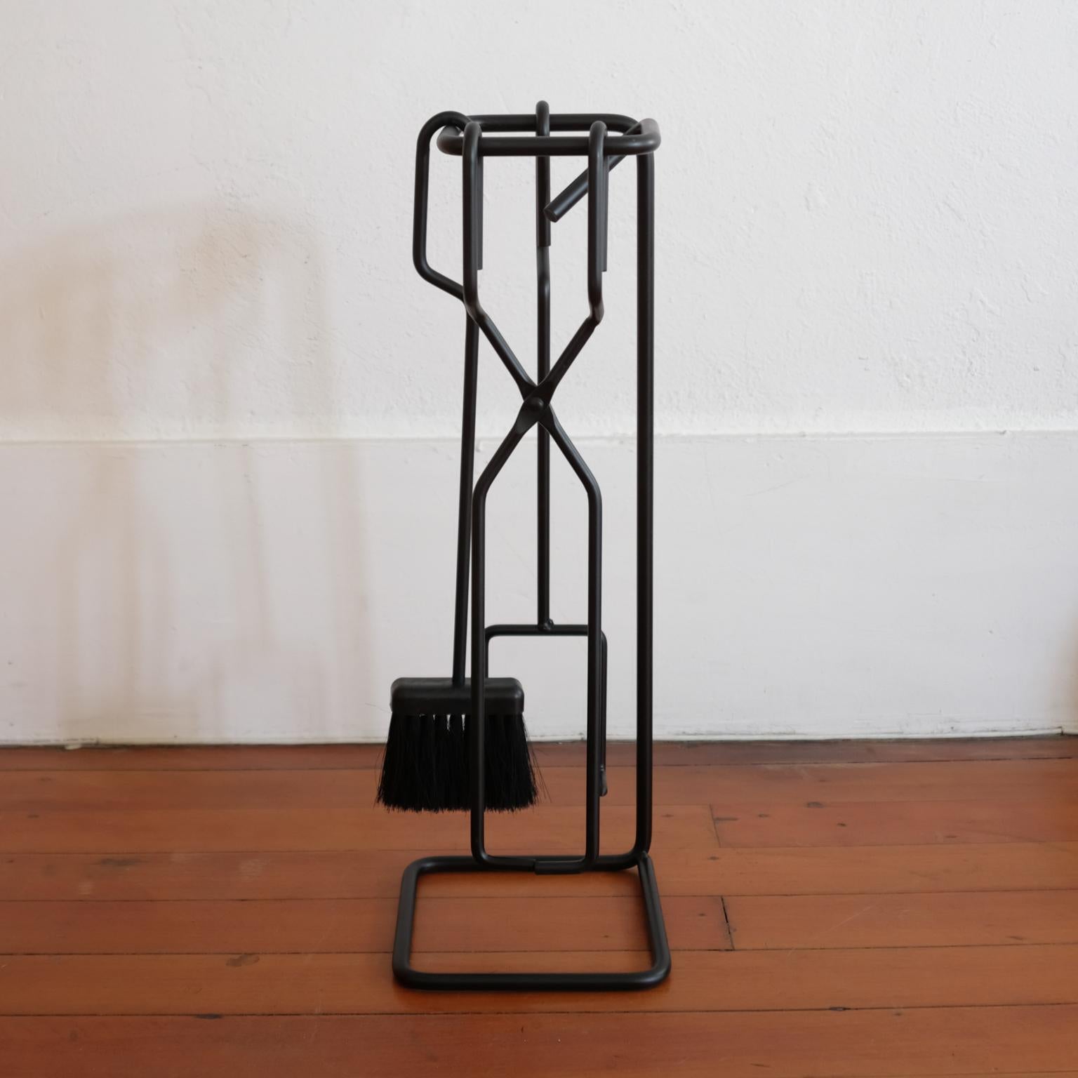 Set of iron fireplace tools hung on a sculptural iron stand. USA, 1950s.