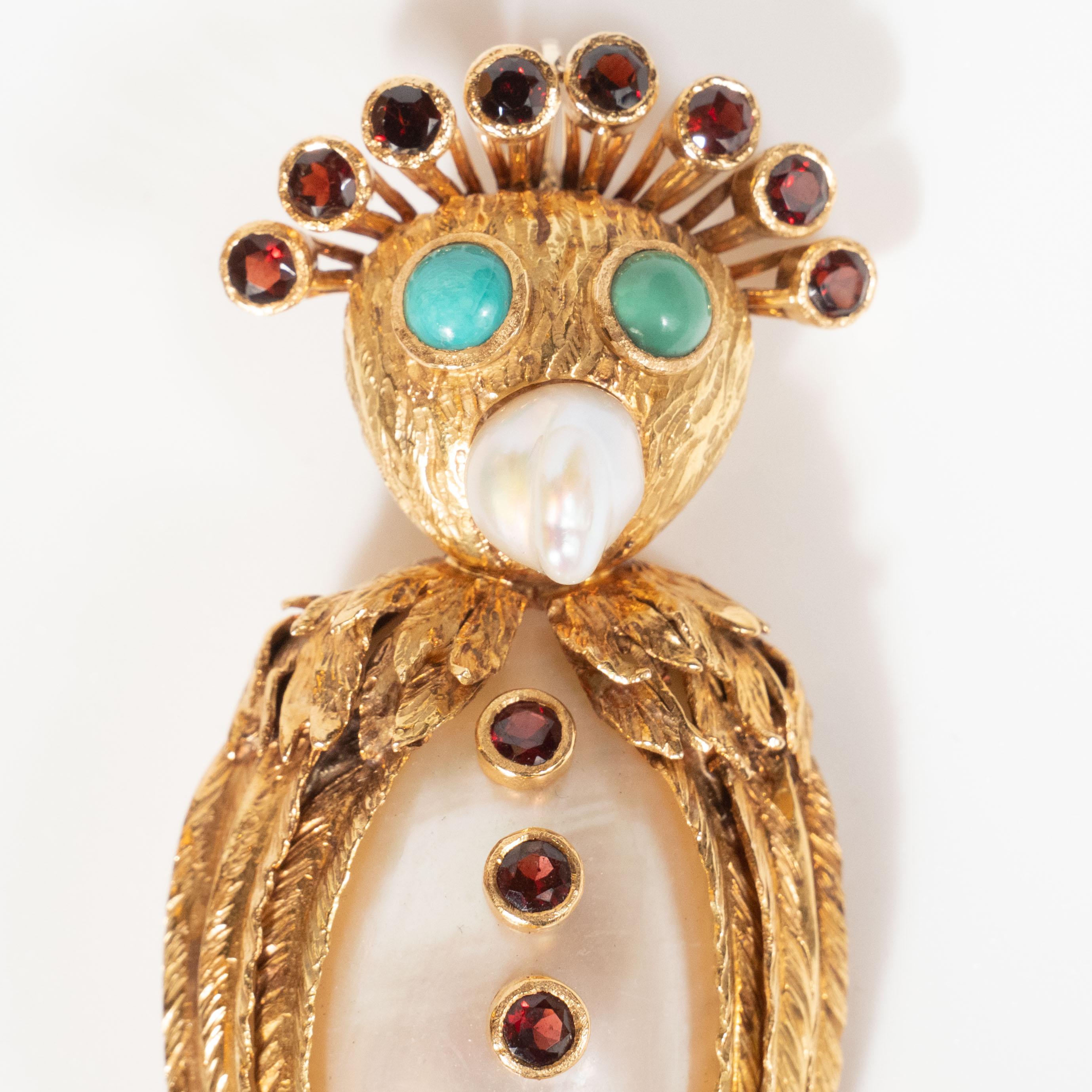 This dazzling and whimsical owl brooch features a nacreous mollusk body adorned with six Campari hued garnet 
