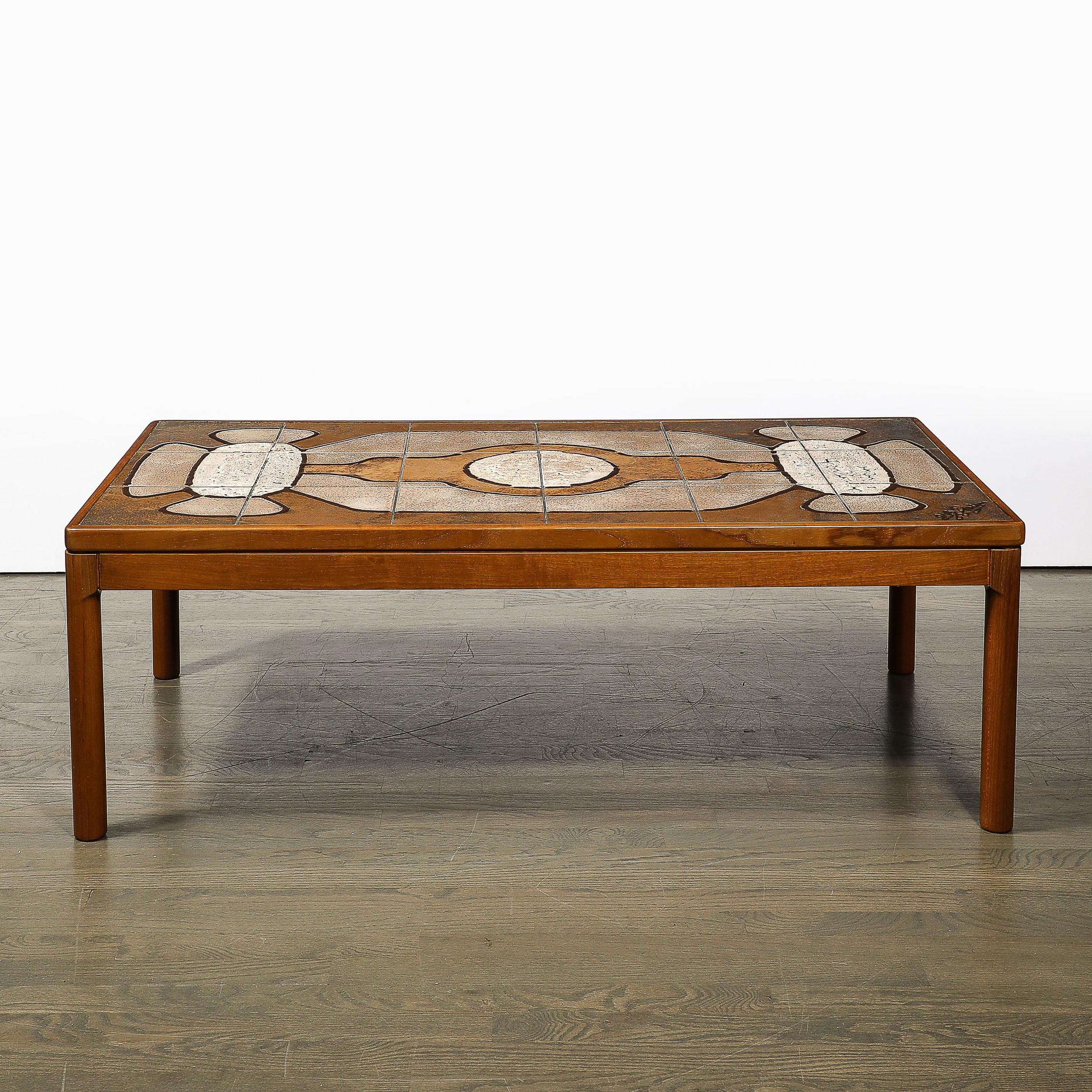 This unique and inviting Mid-Century Modernist Teak Cocktail Table W/Geometric Tile Inlay originates from Denmark, Circa 1960. This piece features a frame composed of teak wood with a lovely hand-rubbed finish, softened edges, and curved corners.