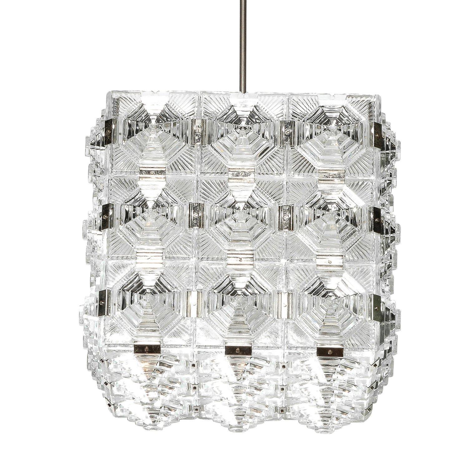 Questo lampadario a sospensione quadrato modernista di metà secolo è stato creato dallo stimato produttore Kinkeldey e proviene dalla Germania, CIRCA 1970. Composto da un paralume in vetro pressato a strati, in stile grattacielo, collegato da un