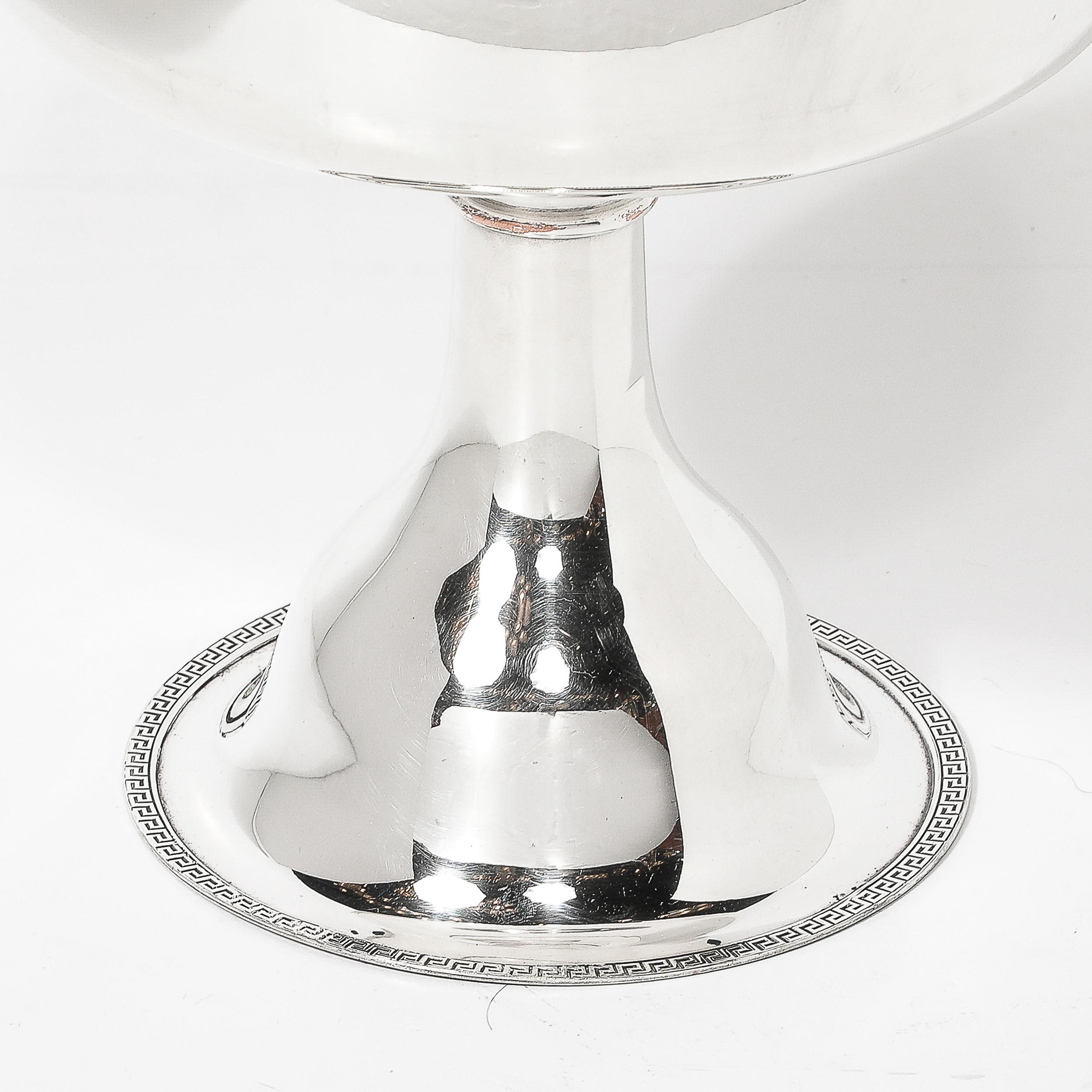 Questa ciotola con piedini placcati in sterling con dettagli a chiave greca, firmata Sheffield, è stata realizzata con cura e in scala audace durante la seconda metà del XX secolo in Inghilterra. Questo pezzo presenta un'elegante silhouette