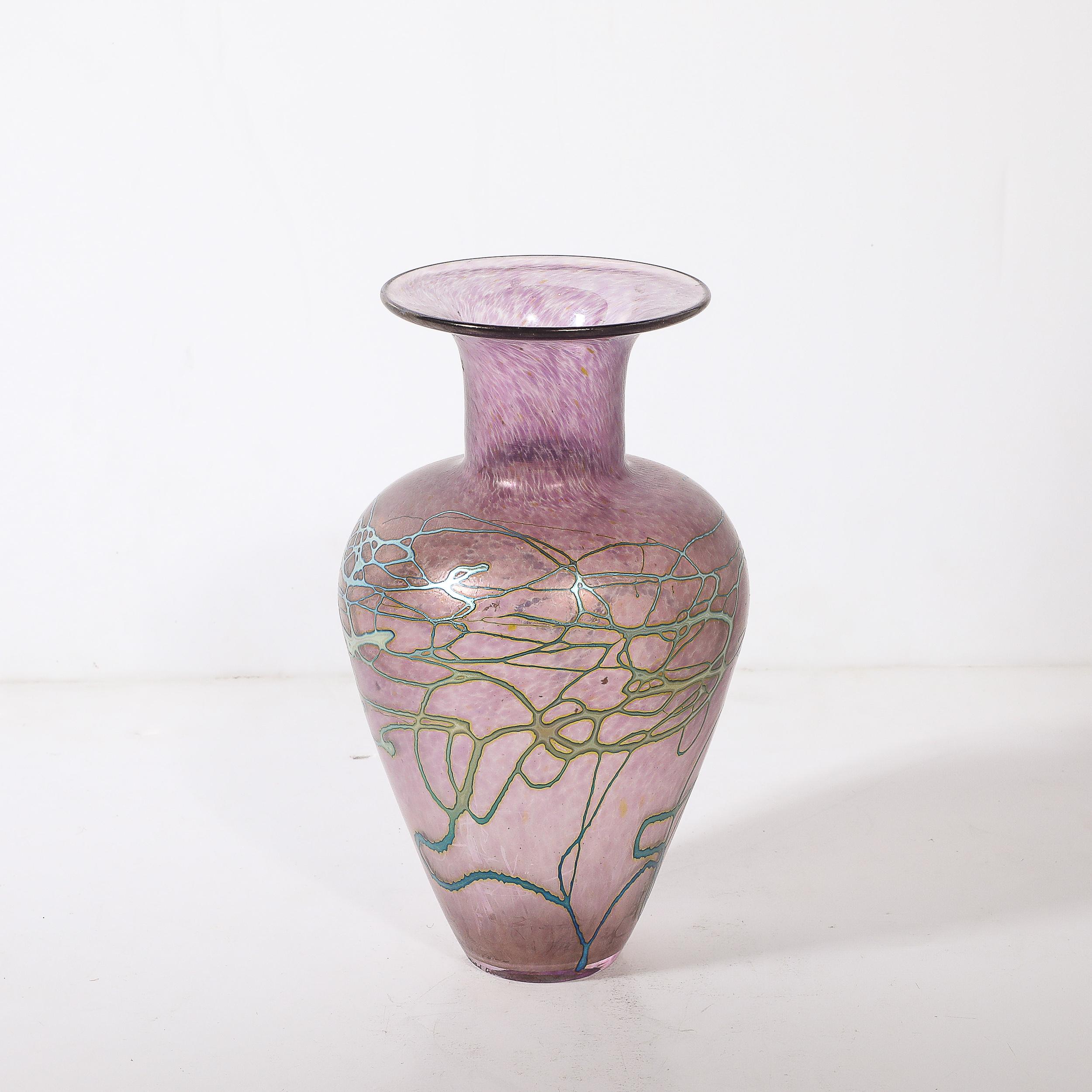 Questo raffinato vaso in vetro artistico modernista del Mid-Century è soffiato a mano e firmato dal rinomato artista canadese Robert Held. Il pezzo presenta un ricco colore viola, delicatamente accentuato da dettagli organici lineari verde