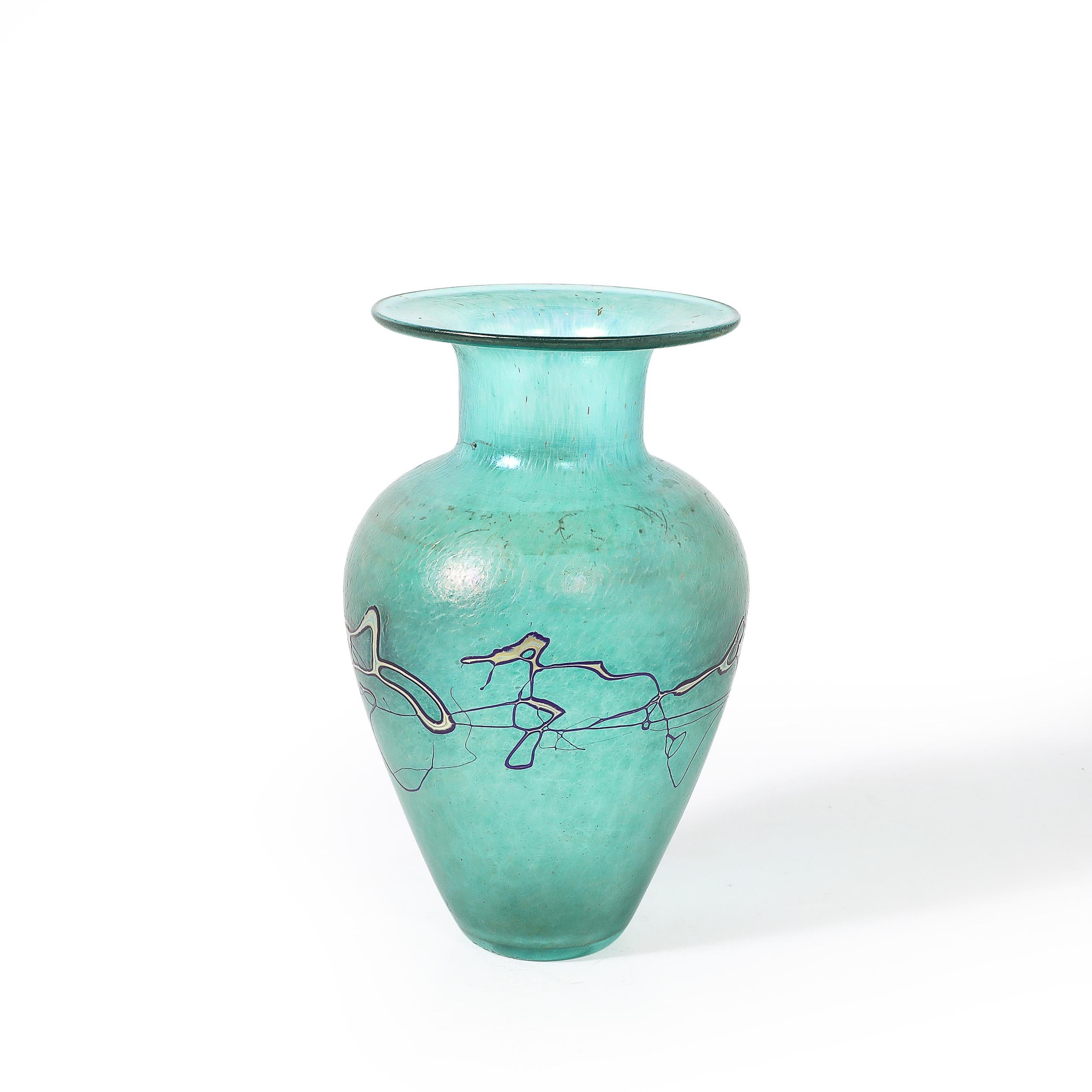 Questo vaso in vetro artistico modernista di metà secolo, sobrio e accattivante, è soffiato a mano e firmato dall'acclamato artista canadese Robert Held. Il pezzo presenta una splendida tonalità di verde, accentuata da dettagli lineari organici