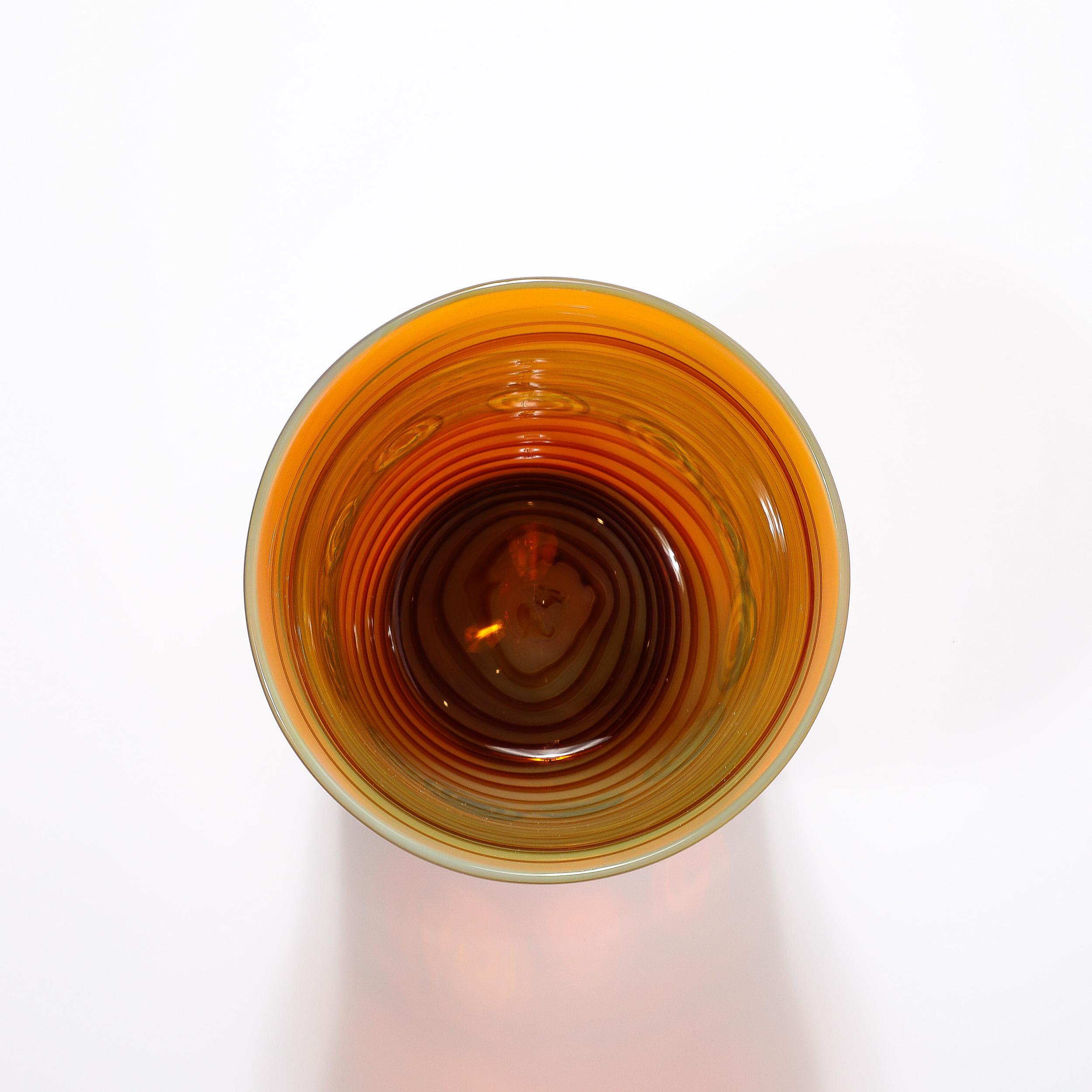 Ce magnifique vase en verre de Murano soufflé à la main, de style moderniste du milieu du siècle, avec des bandes de citrine et des anneaux d'ambre, est originaire d'Italie et date de la seconde moitié du XXe siècle. Le vase présente une jolie forme