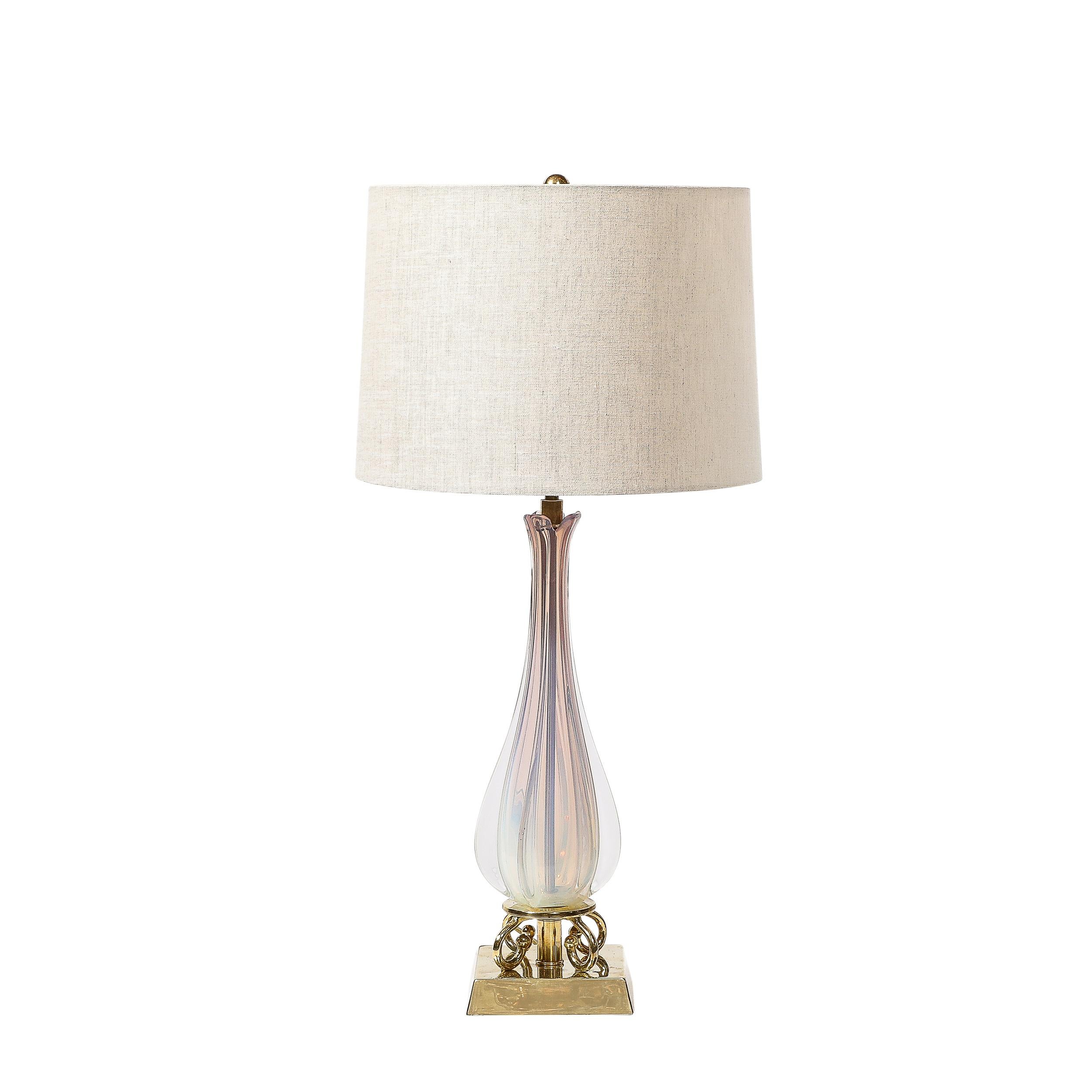 This highly elegant Pair of Mid-Century Modernist Hand-Blown Fluted & Opalescent Murano Glass Table Lamps originates from Italy, Circa 1950. They feature stunning sculptural bases formed in polished brass, rectangular with faceted sides and curled