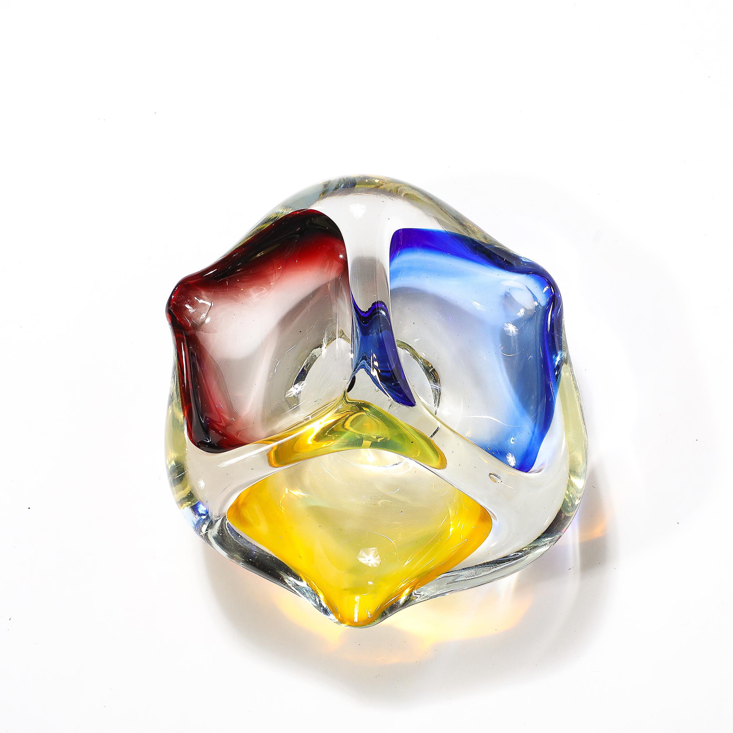 This striking mid-century modernist dish/ashtray, hand-blown in Murano, Italy circa 1960, showcases the vibrant artistry and craftsmanship that the renowned Murano glassmakers are celebrated for. The piece features a captivating blend of blue,