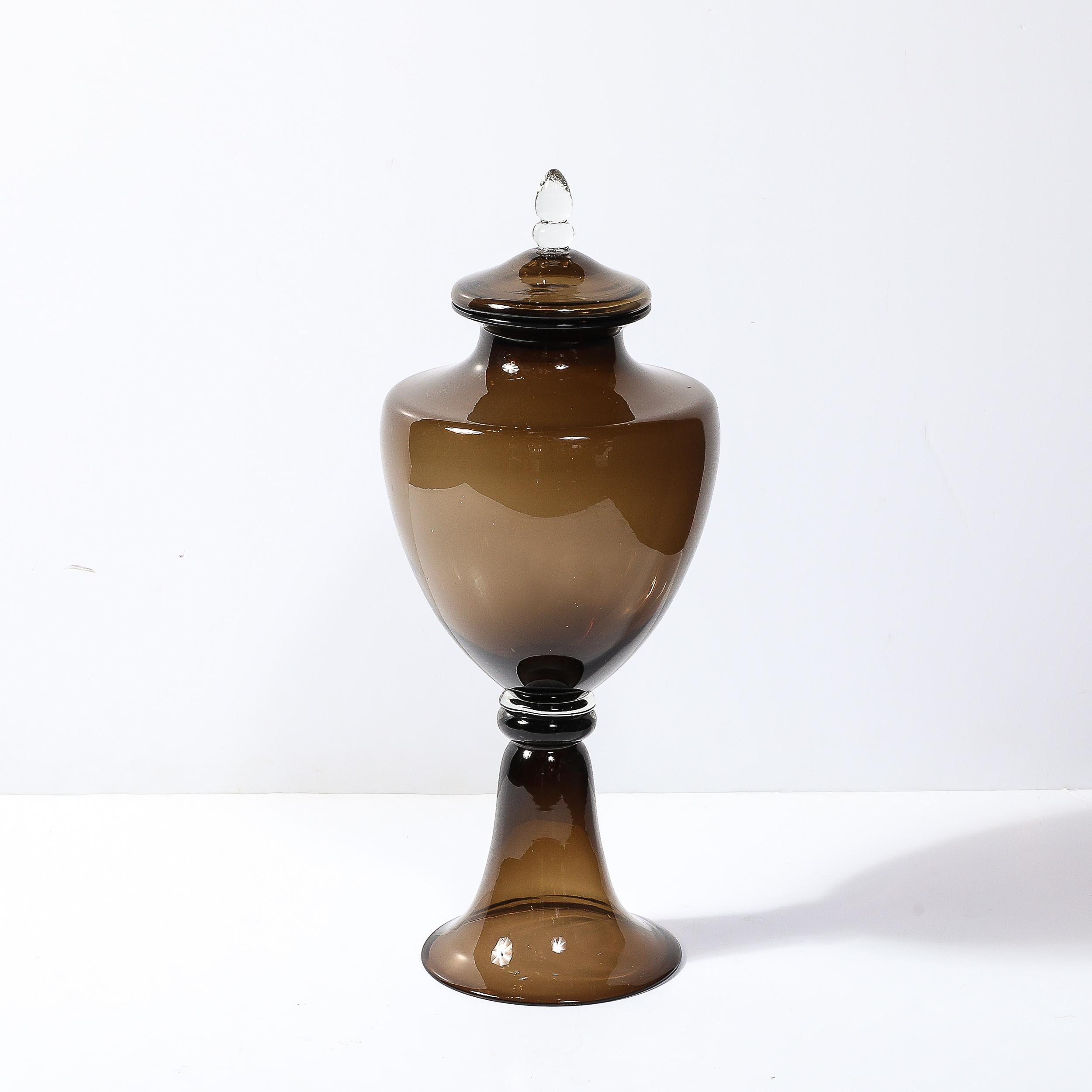 Questo audace e unico centrotavola in vetro di Murano soffiato a mano, in stile Mid-Century Modernist, proviene dall'Italia, intorno al 1960. Presenta una splendida silhouette realizzata in vetro fumé con sottili dettagli trasparenti, creando una