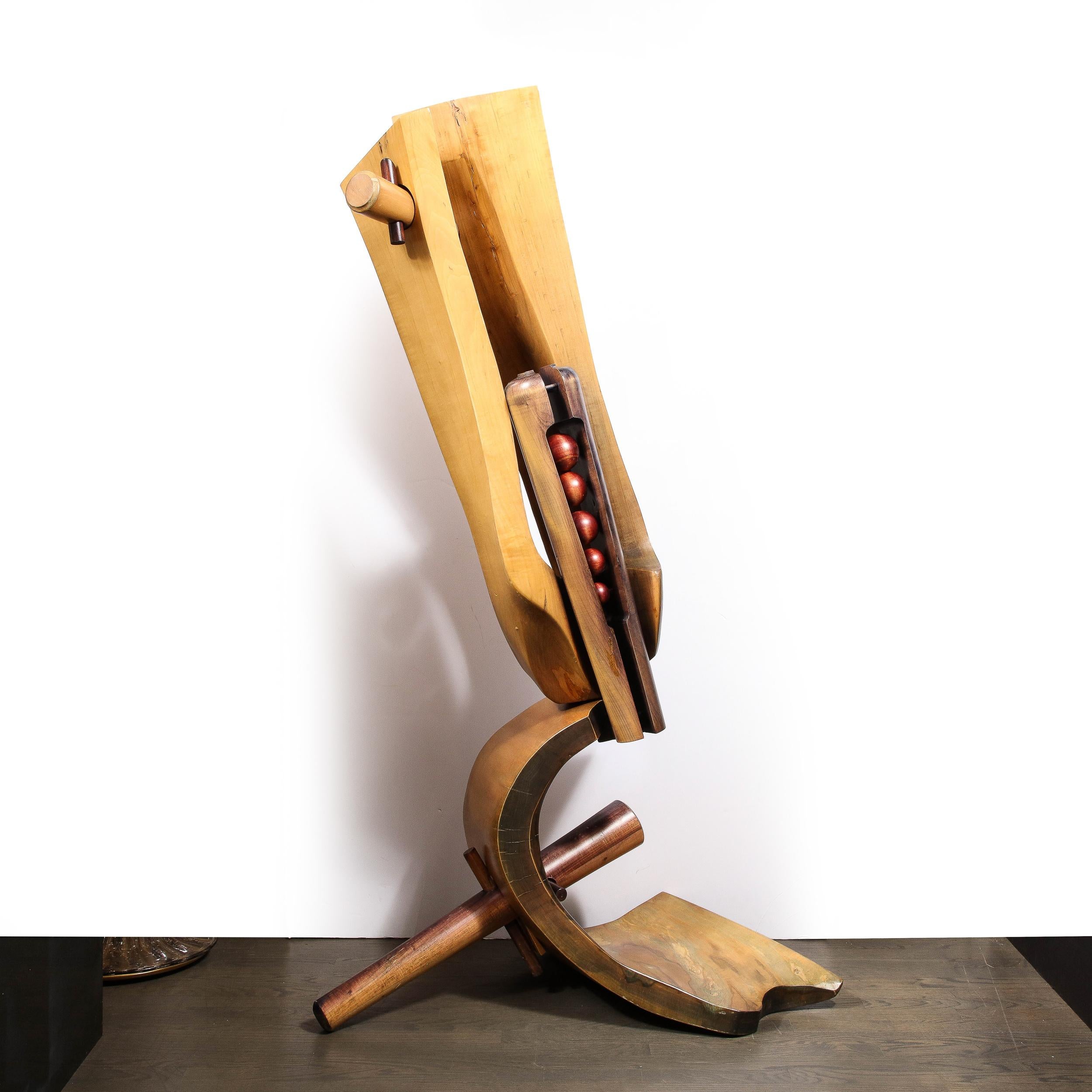 This unusual and sophisticated modernist sculpture was realized in France circa 1985. It features a demilune formed base suggestive of a sickle in oak pierced through with a cylindrical dowel in burnished walnut. The amorphic oak body suggests an