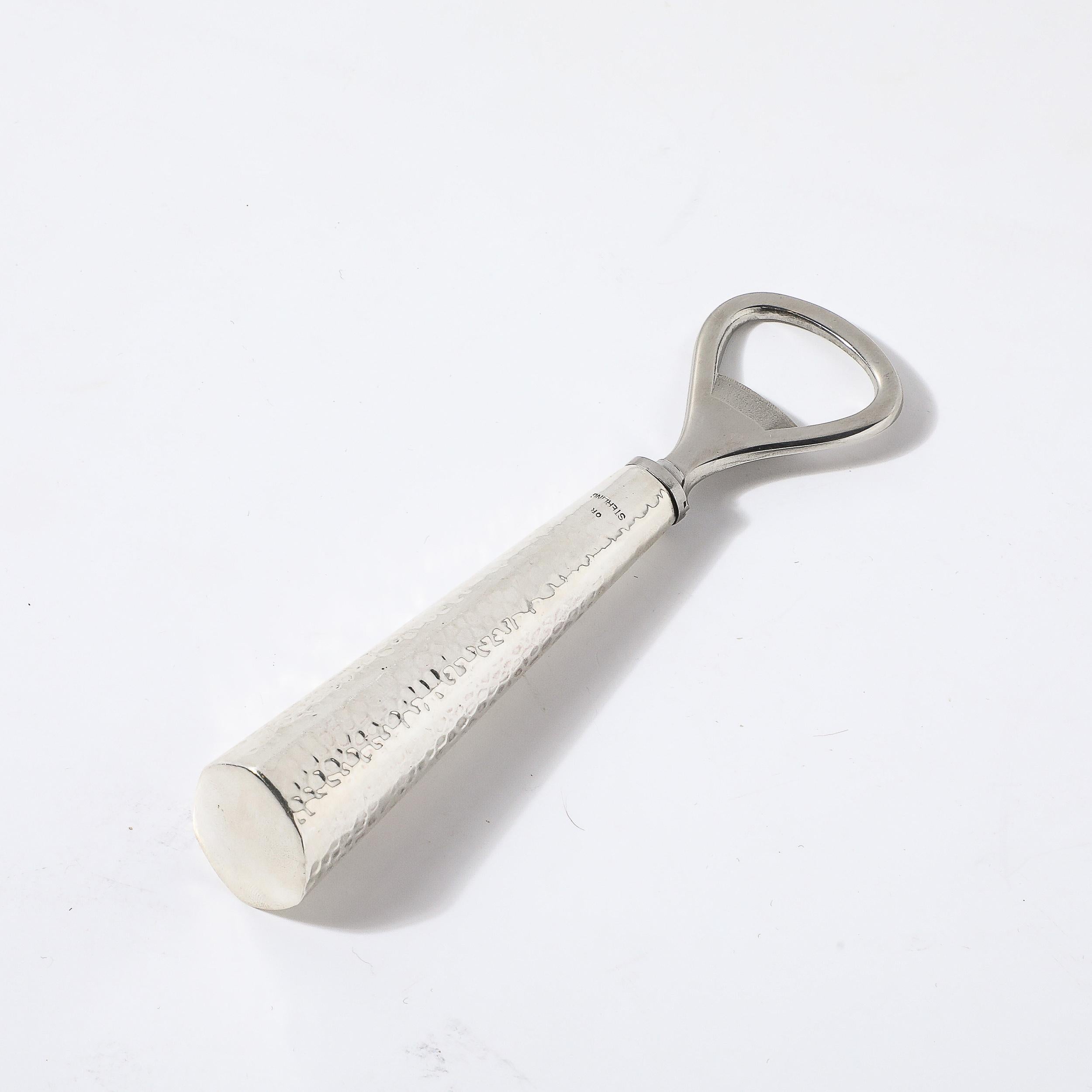 Questo scintillante apribottiglie in argento sterling martellato a mano, in stile Mid-Century Modernist, proviene dagli Stati Uniti, circa dal 1950. Questo pezzo presenta un manico con una forma affusolata e graduata che si espande verso la base,