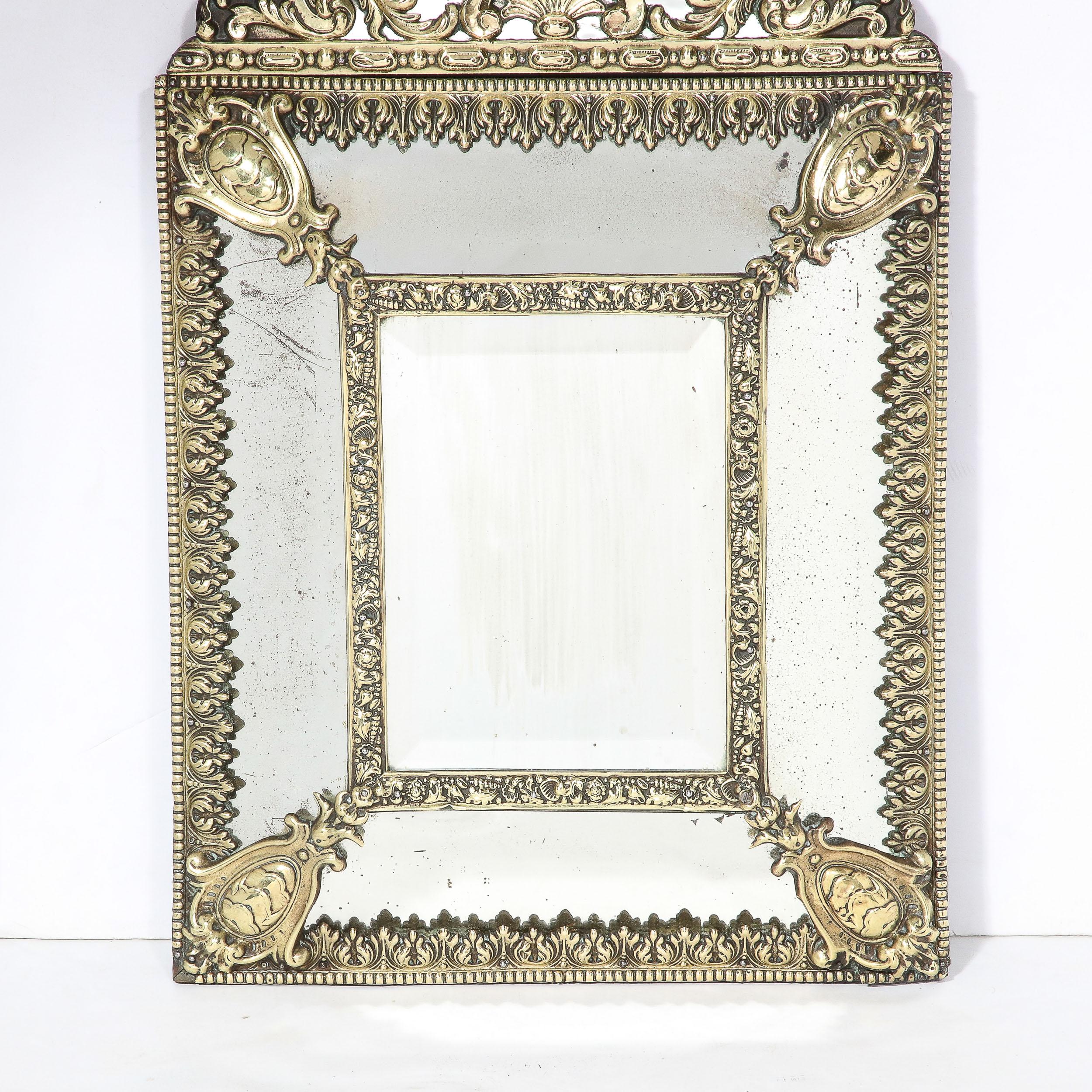 This gleaming Mid-Century Modernist Hollywood Regency Gilt Repousse Mirror Originates from the United States, Circa 1940. Featuring five panels of antiqued mirror glass lined in a stunning Gilt Repousse frame, the detailing and material contrast