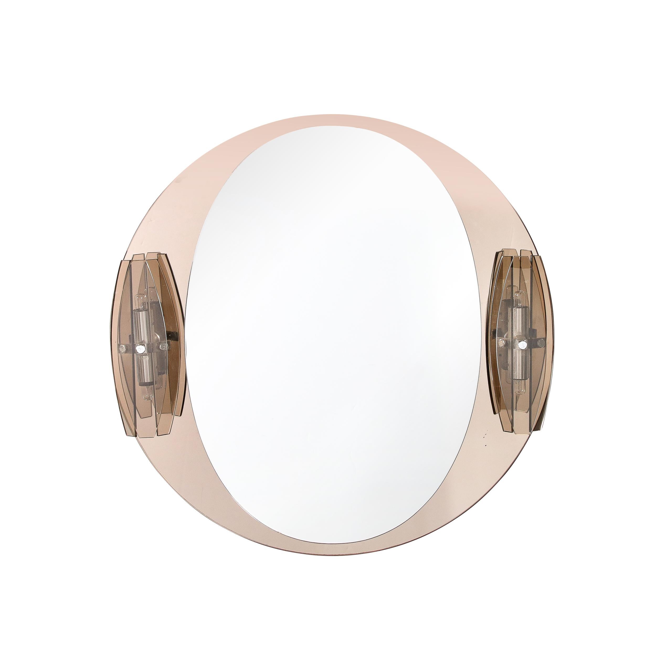 This Mid-Century modernist Illuminated Vanity Mirror was crafted by VECA, originating from Italy, Circa 1970. Composed in Bronzed and Smoked mirror glass with translucent smoked bronze panels shielding the bulbs, this unique sculptural piece is a