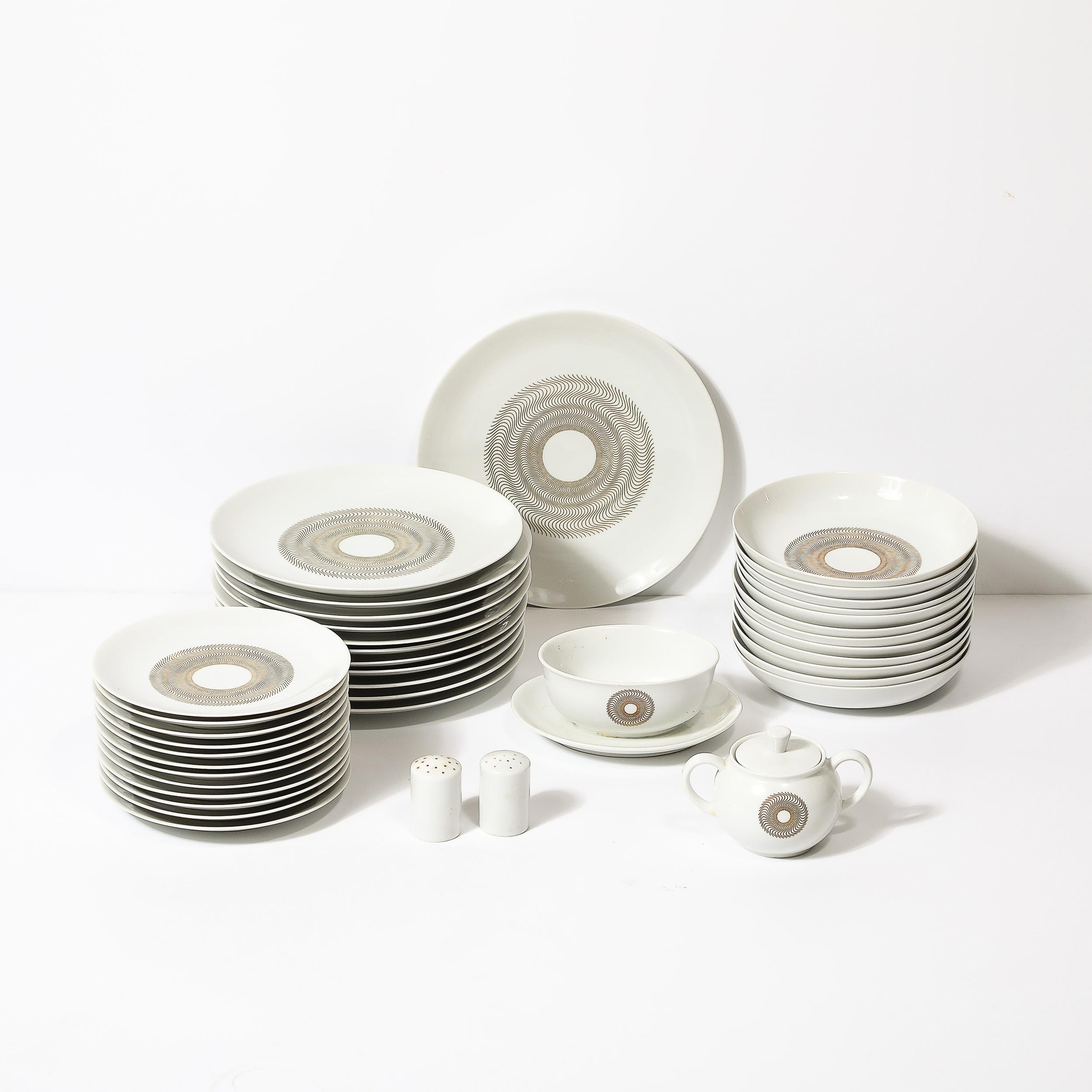 This beautiful Mid-Century Modernist Jean Luce Jlu1 Pattern Porcelain Service for 12 originates from Germany, Circa 1950. Featuring an array of pieces, each is composed in a beautiful porcelain with radiating gilt detailing in an array of wavy lines