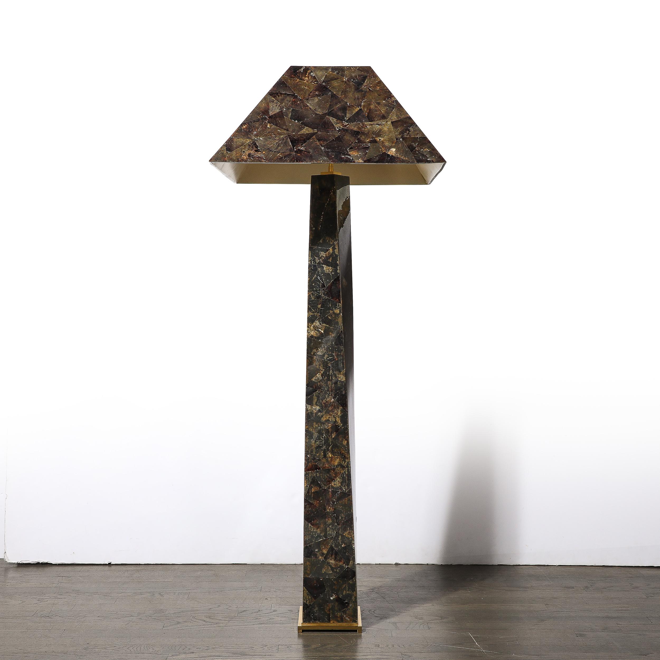 This materially stunning and unique floor lamp originates from the United States circa 1980. Features a minimal square polished brass base from which a gorgeous geometric triangular body of the floor lamp rises with a half twist, fitted with the