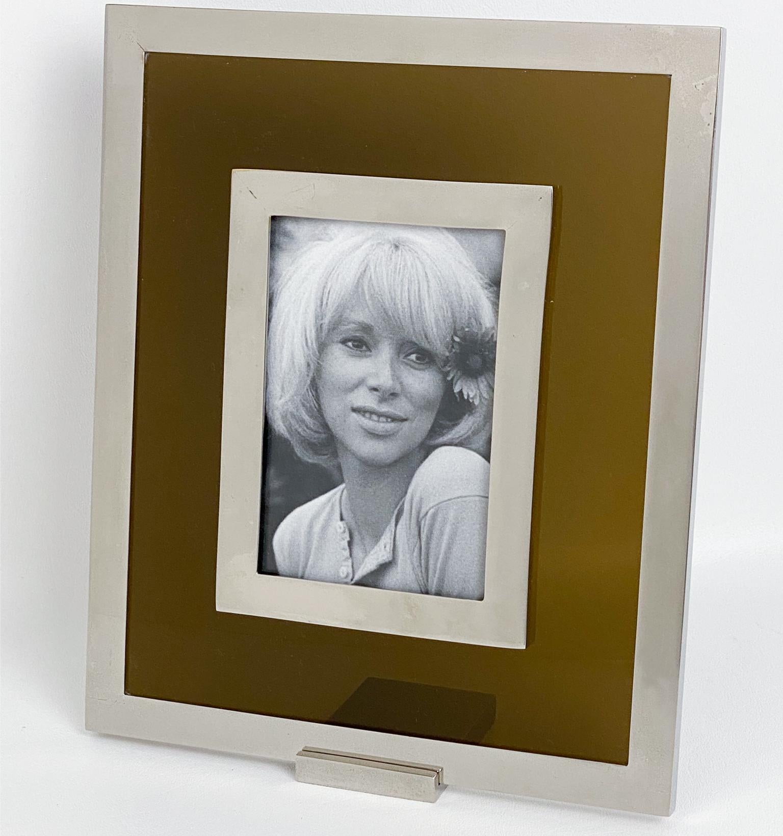 This stunning Mid-Century picture frame was crafted in Italy circa 1970. The rare easel-type table photo holder features a smoke amber Lucite frame and chromed metal, giving it a classic 1970s look. Glass protection ensures that your treasured