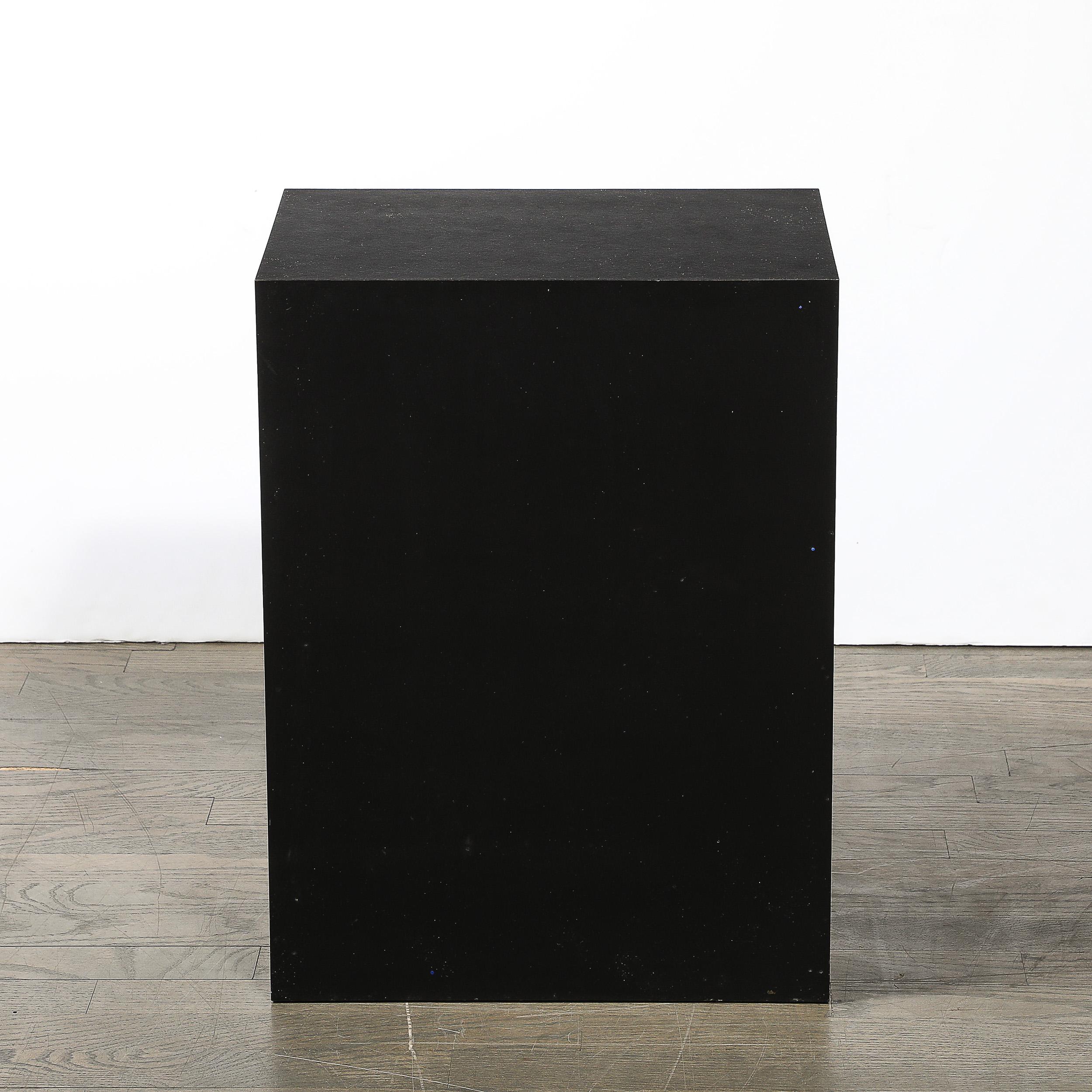 Questo piedistallo modernista di metà secolo in laminato nero opaco è un pezzo sorprendente che riflette l'estetica pulita e minimalista caratteristica della metà del XX secolo. Realizzato in America, questo piedistallo incarna i principi modernisti