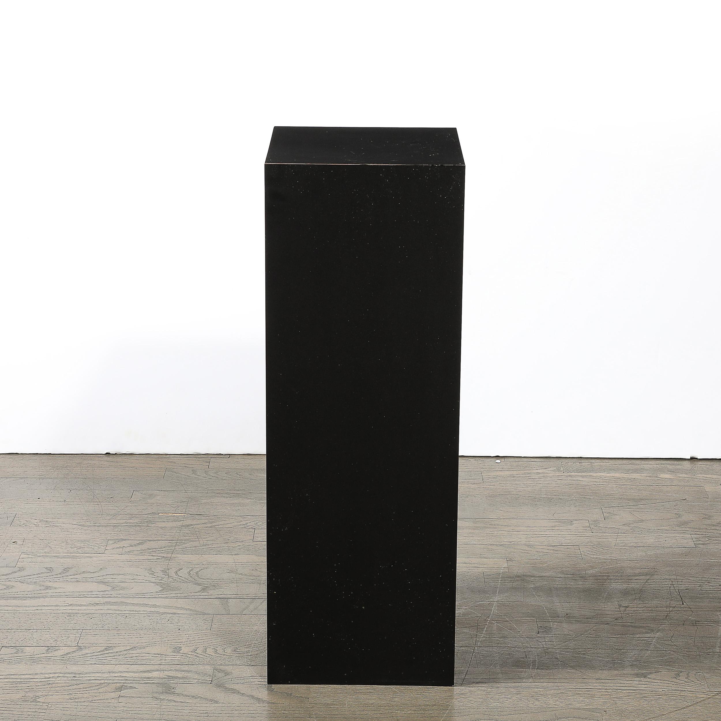 Questo piedistallo modernista di metà secolo in laminato nero opaco è un pezzo sorprendente che riflette l'estetica pulita e minimalista caratteristica della metà del XX secolo. Realizzato in America, questo piedistallo incarna i principi modernisti