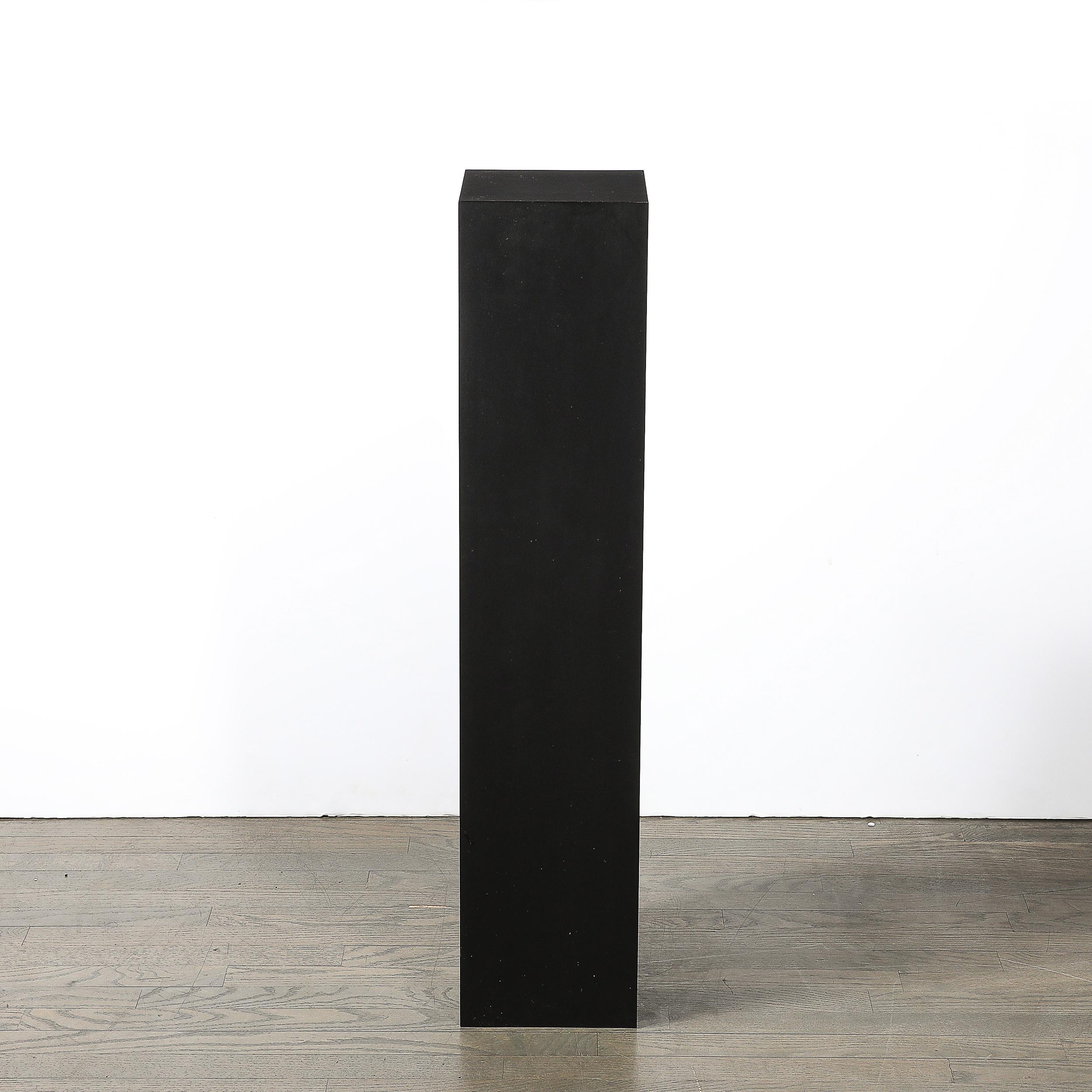 Questo piedistallo modernista di metà secolo in laminato nero opaco è un pezzo sorprendente che riflette l'estetica pulita e minimalista caratteristica della metà del XX secolo. Realizzato in America, questo piedistallo incarna i principi modernisti
