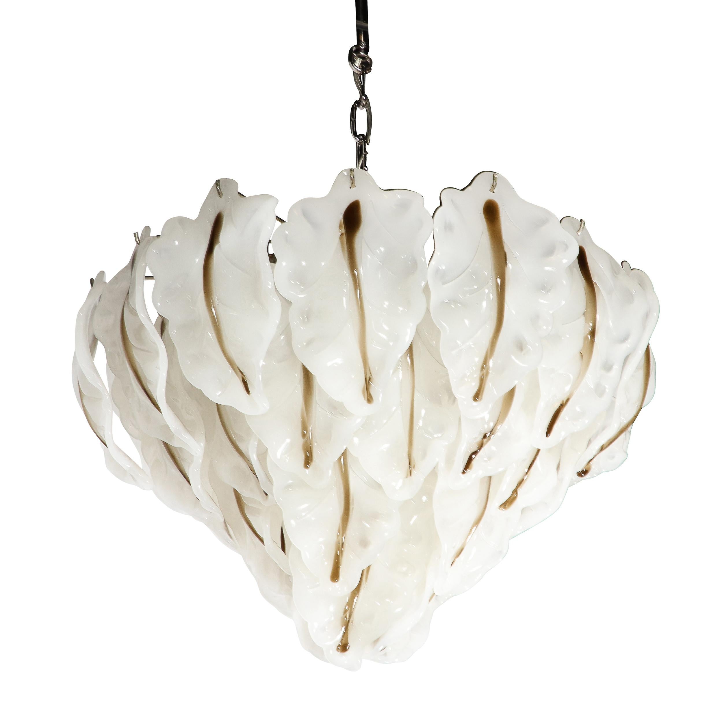 This bold and elegant Mid-Century Modernist Murano Glass Leaf Chandelier by Mazzega originates from Italy, Circa 1970. Features four graduated tiers of Hand-Blown leaf form glass elements in white with a subtle line of raw umber along the center of