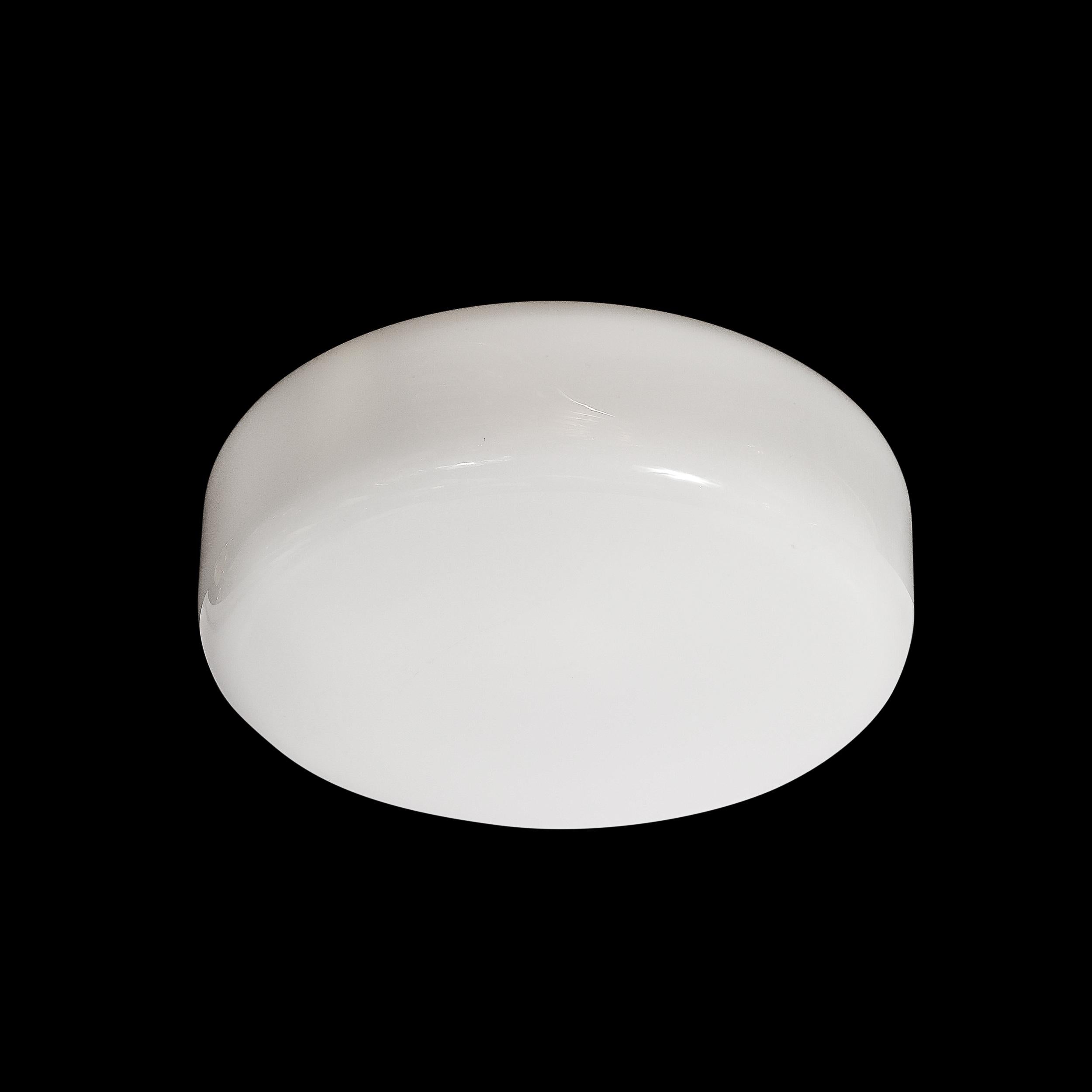 Questo lampadario a incasso in vetro lattiginoso del Mid-Century Modernist proviene dalla Scandinavia, CIRCA 1960. Presenta una composizione cilindrica minimale in vetro lattimo con bordi arrotondati e un raccordo in bronzo oliato a fascia che lo