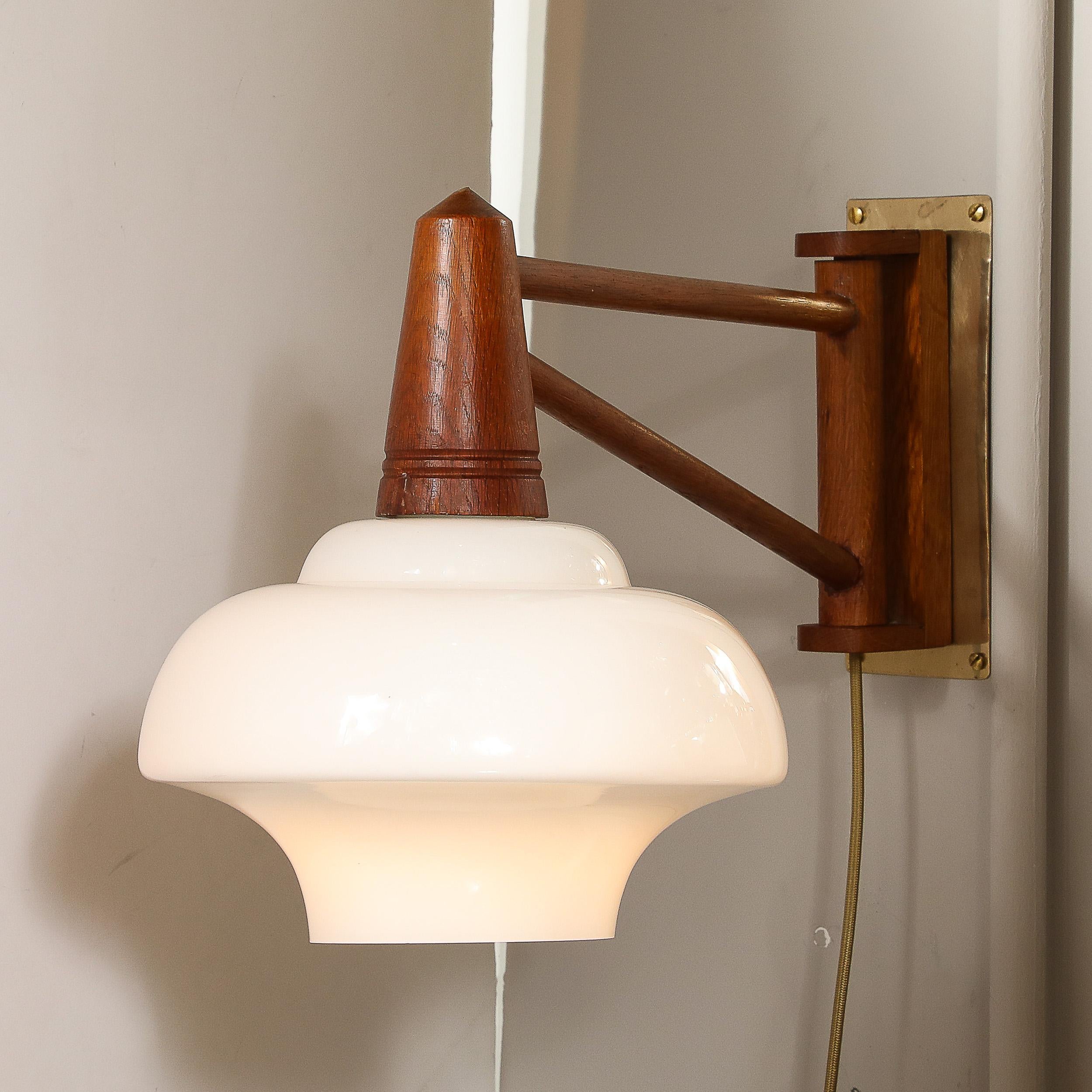 This elegant piece perfectly encapsulates the minimal and functional aesthetics of Mid-Century Modern design, combining high-quality materials with masterful craftsmanship.
The sconce features an elegant curvilinear milk glass shade that exudes a