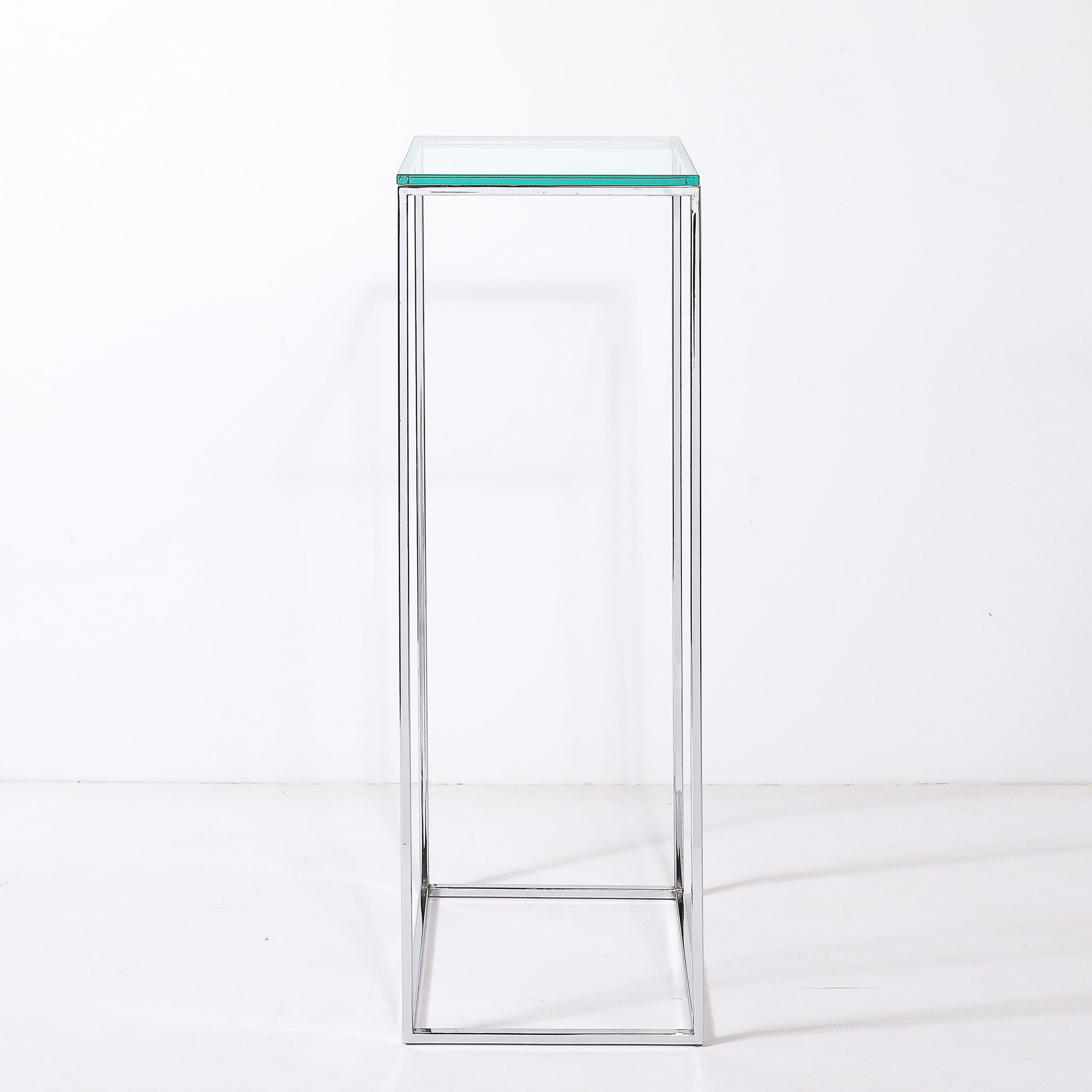 Ce piédestal rectiligne minimal et épuré de style moderniste du milieu du siècle, en chrome, avec plateau en verre, provient des États-Unis, vers 1970. Il se caractérise par une construction minimale en poutres rectangulaires étroites en chrome