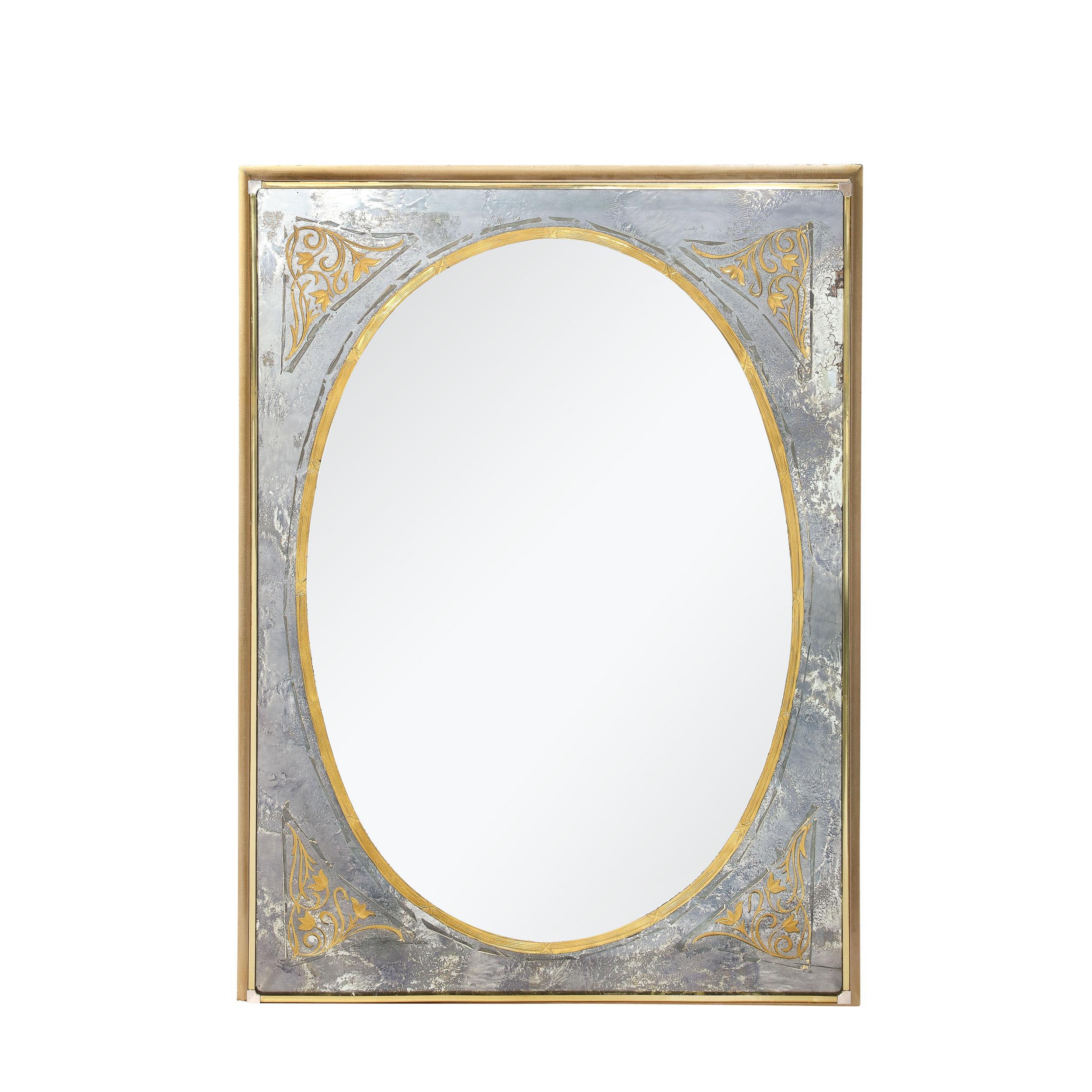 This elegant and materially dynamic Mid-Century Modernist Mirror in Gilt Eglomise With Antiqued Smoked Border originates from the United States, Circa 1950. Features an oval form central pane of plain mirror lined with a stip of gilt eglomise