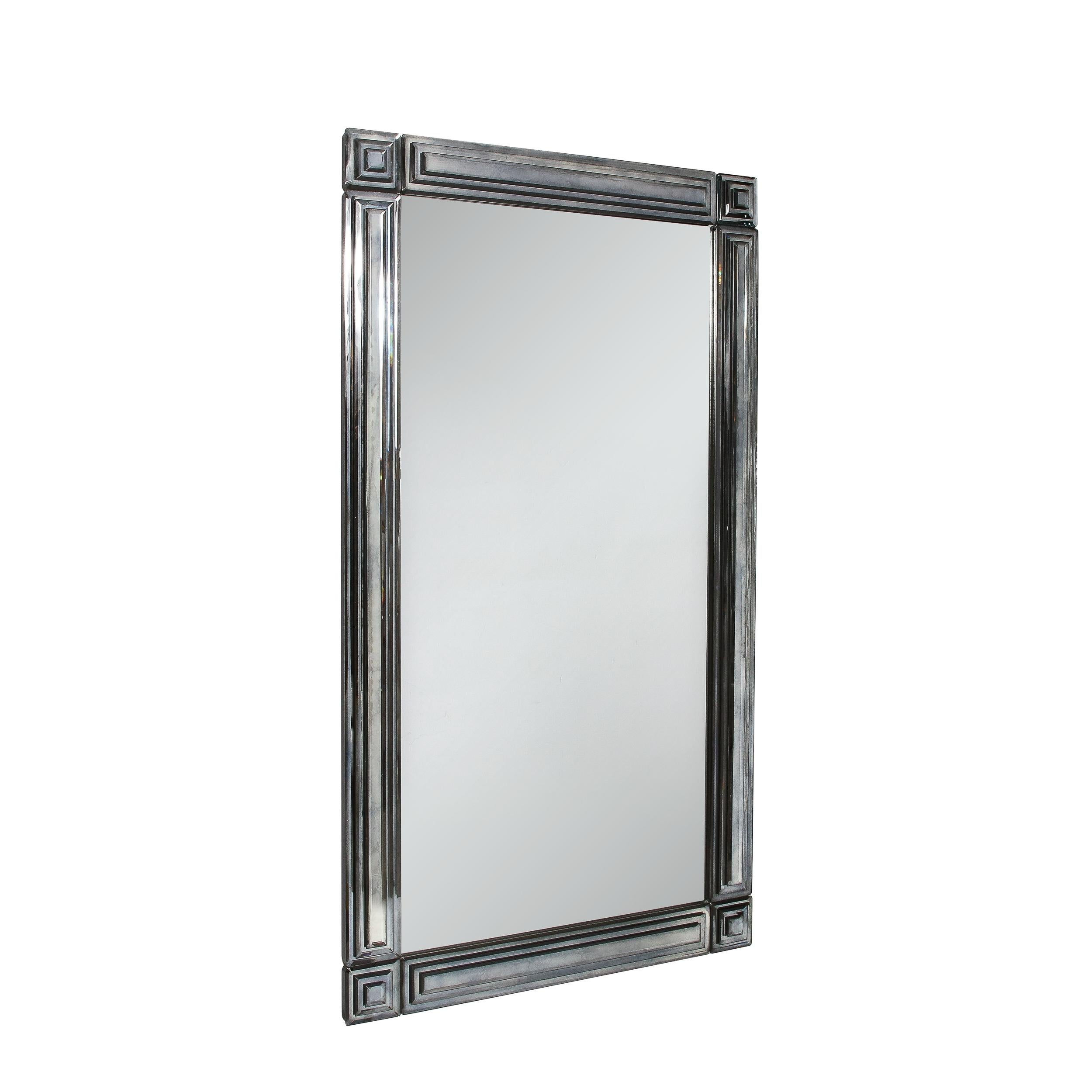 This beautiful Mid-Century Modernist Mirror with Tiered and Beveled Geometric Smoked Border originates from the United States, Circa 1970. Featuring a vertical profile with a stunning surface, this piece has a bold presence, accentuated by the