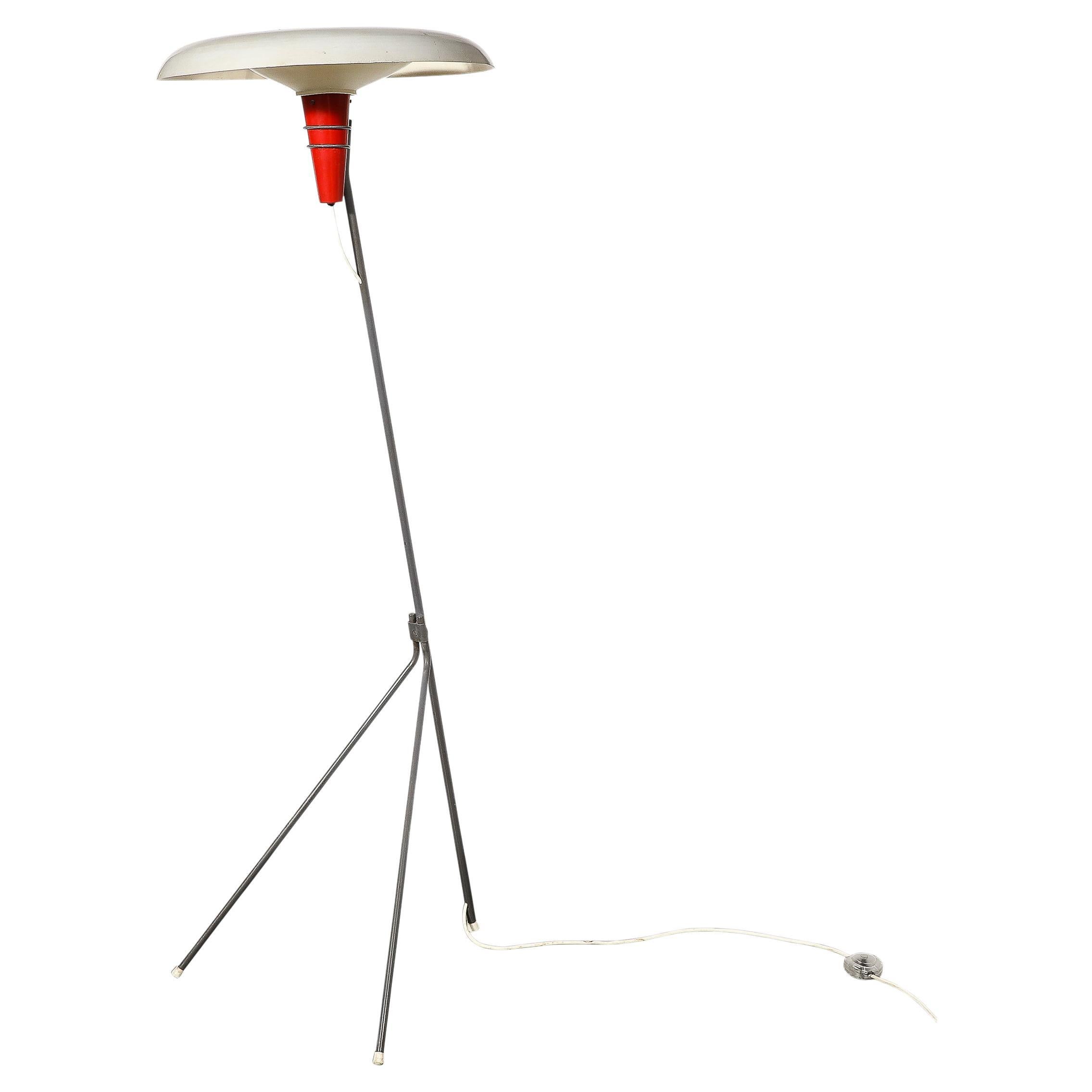 This unique and materially dynamic Mid-Century Modernist “NX38” Floor Lamp is designed by Louis Kalff for Philips and originates from the Netherlands, Circa 1950. Features a large saucer form shade in off white enameled metal. Beneath the lip of the