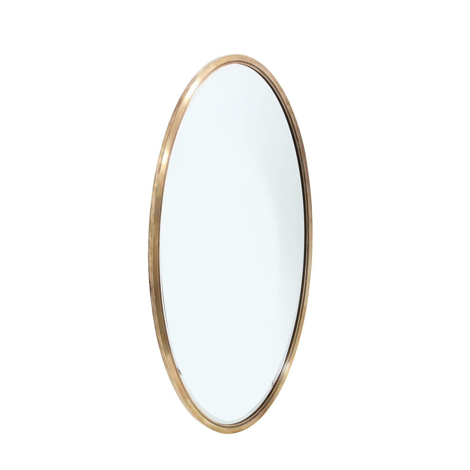 Questo specchio ovale del Mid-Century Modernist con cornice in ottone lucido, ben dimensionato e audace, proviene dagli Stati Uniti, circa dal 1960. Presenta una splendida struttura rettilinea in ottone massiccio con finitura lucida e sottili