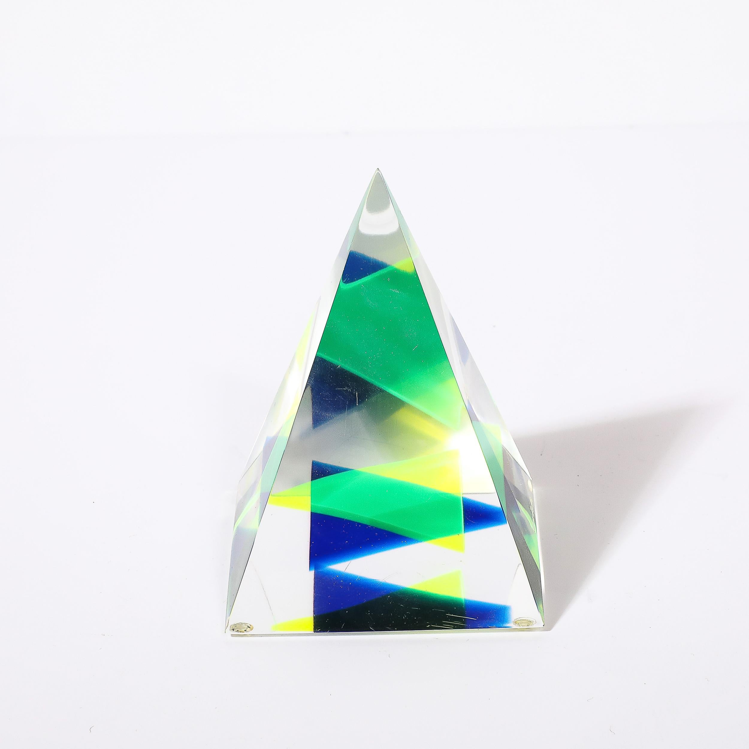 Cette sculpture pyramidale en lucite, unique et géométriquement dynamique, est signée par Yaccov Heller et provient des États-Unis, vers 1970. Elle présente une forme pyramidale avec de jolis jaune, turquoise et bleu outremer dispersés à l'intérieur