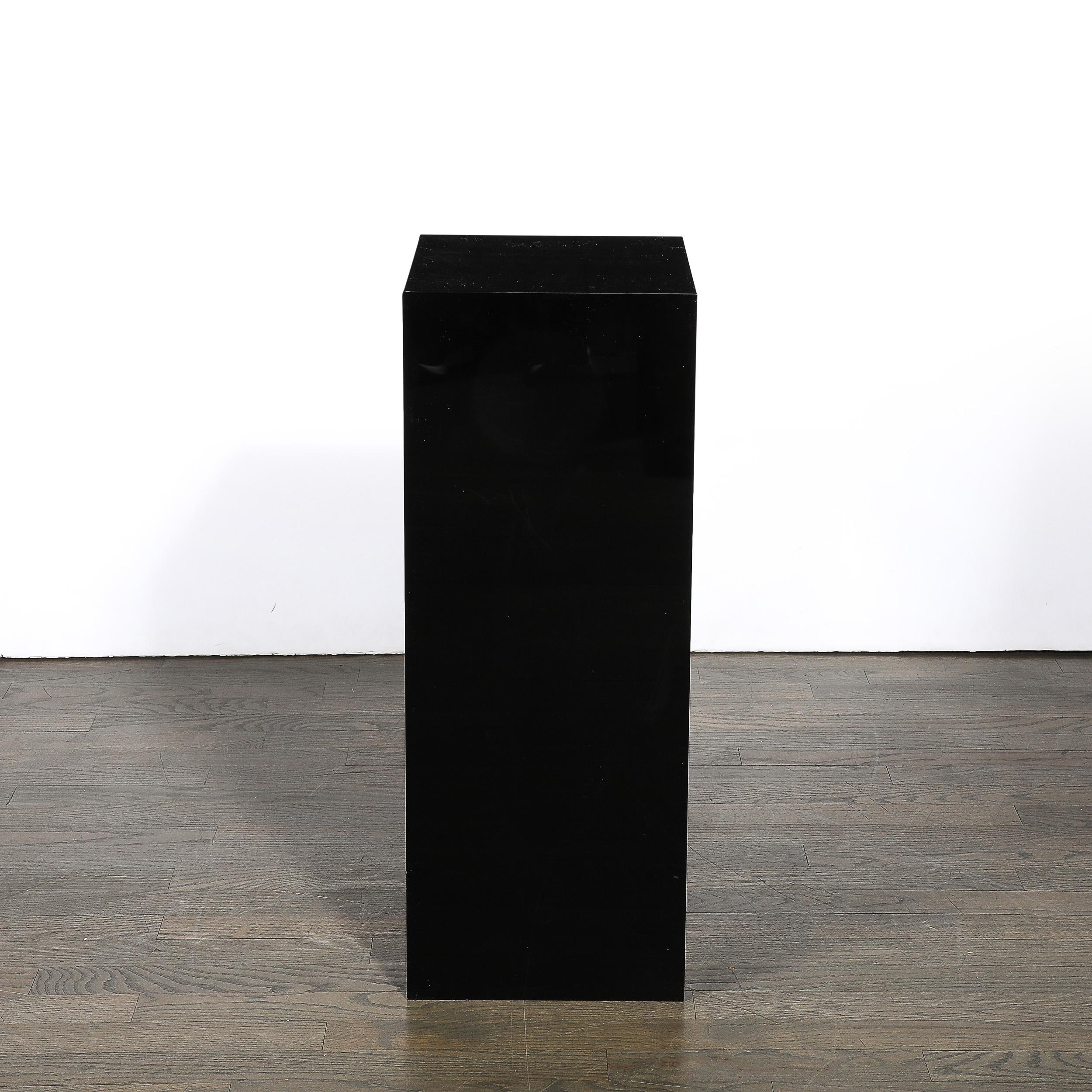 Dieser minimalistische und materiell hervorragende Mid-Century Modernist Rectilinear Black Acrylic Pedestal stammt aus den Vereinigten Staaten aus der zweiten Hälfte des 20. Jahrhunderts. Die geradlinige Komposition besteht aus glänzendem schwarzem