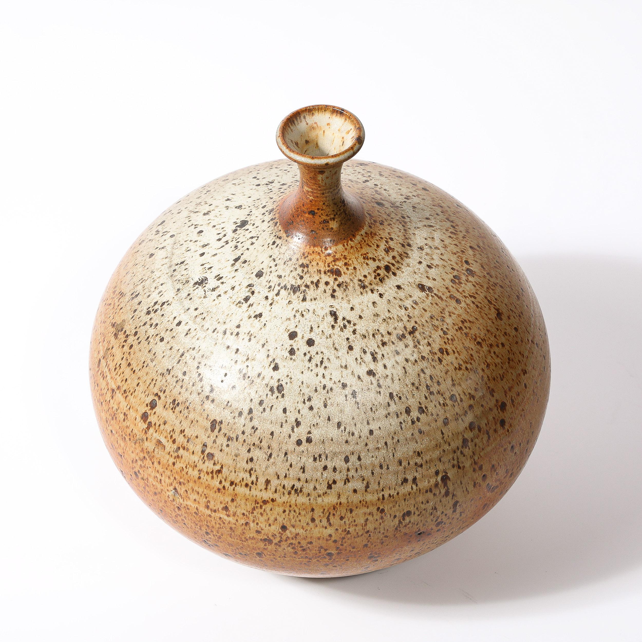This beautifully formed and materially sensitive Mid-Century Modernist Round Speckled Earth Tone Ceramic Vase W/ Tapered Neck originates from the United States, Circa 1960. Features a narrow tapered neck that leads to a beautifully rounded body