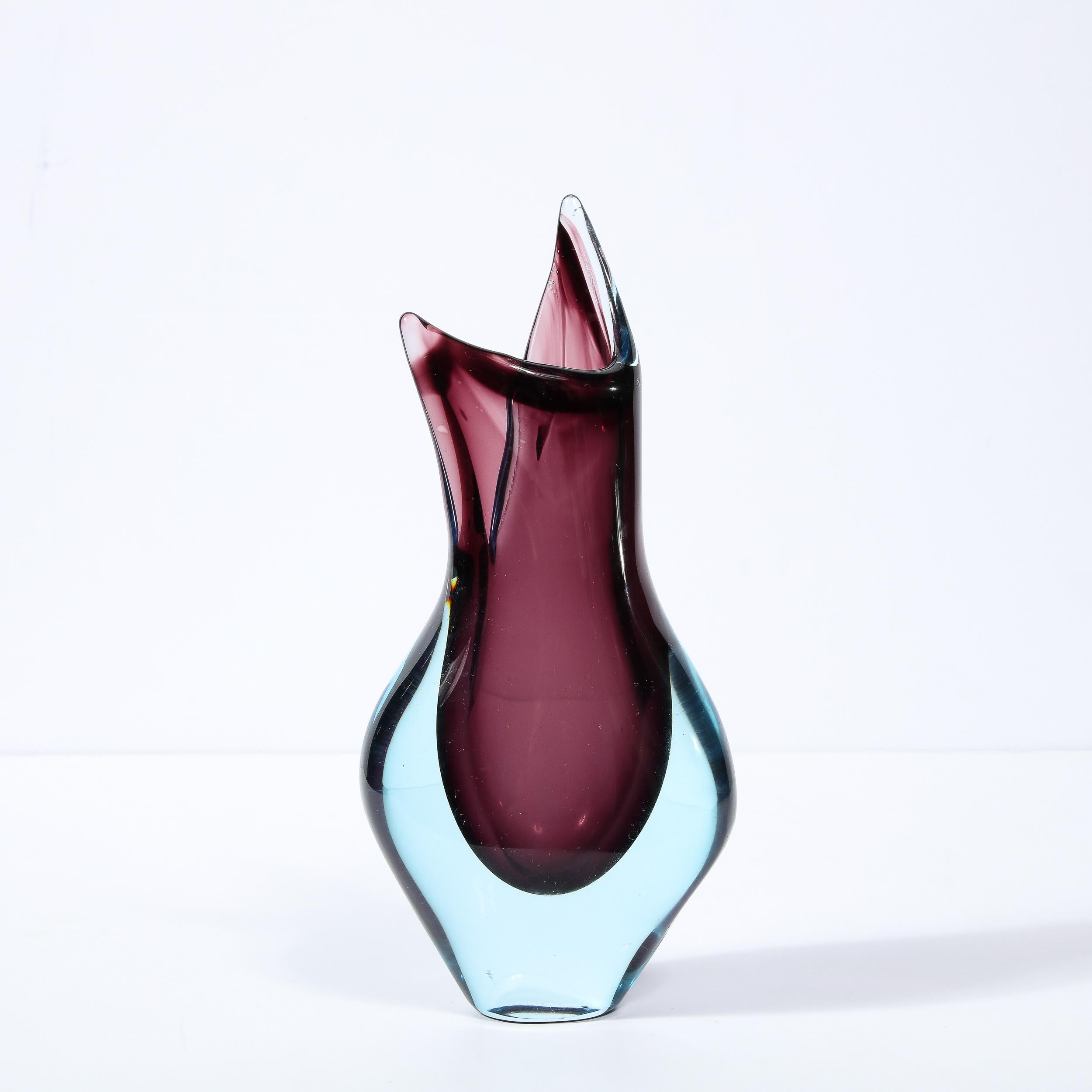 This elegant and graphic Mid-Century Modern vase was realized in Murano, Italy- the island off the coast of Venice renowned for centuries for its superlative glass production. It features an idiosyncratic, amorphic form that flares dramatically near