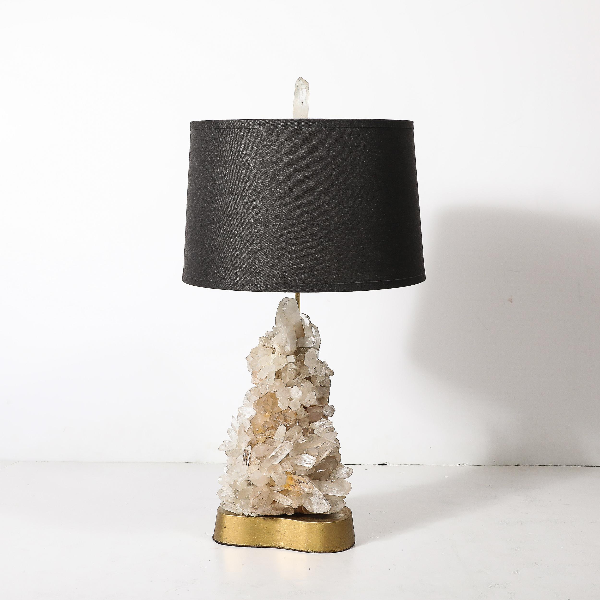 Cette lampe de table exceptionnelle, conçue par Carole Stupell au milieu du XXe siècle, présente un mélange harmonieux d'élégance naturelle et de sensibilité moderniste. Dotée d'un cristal de quartz sculptural comme pièce maîtresse, la lampe incarne