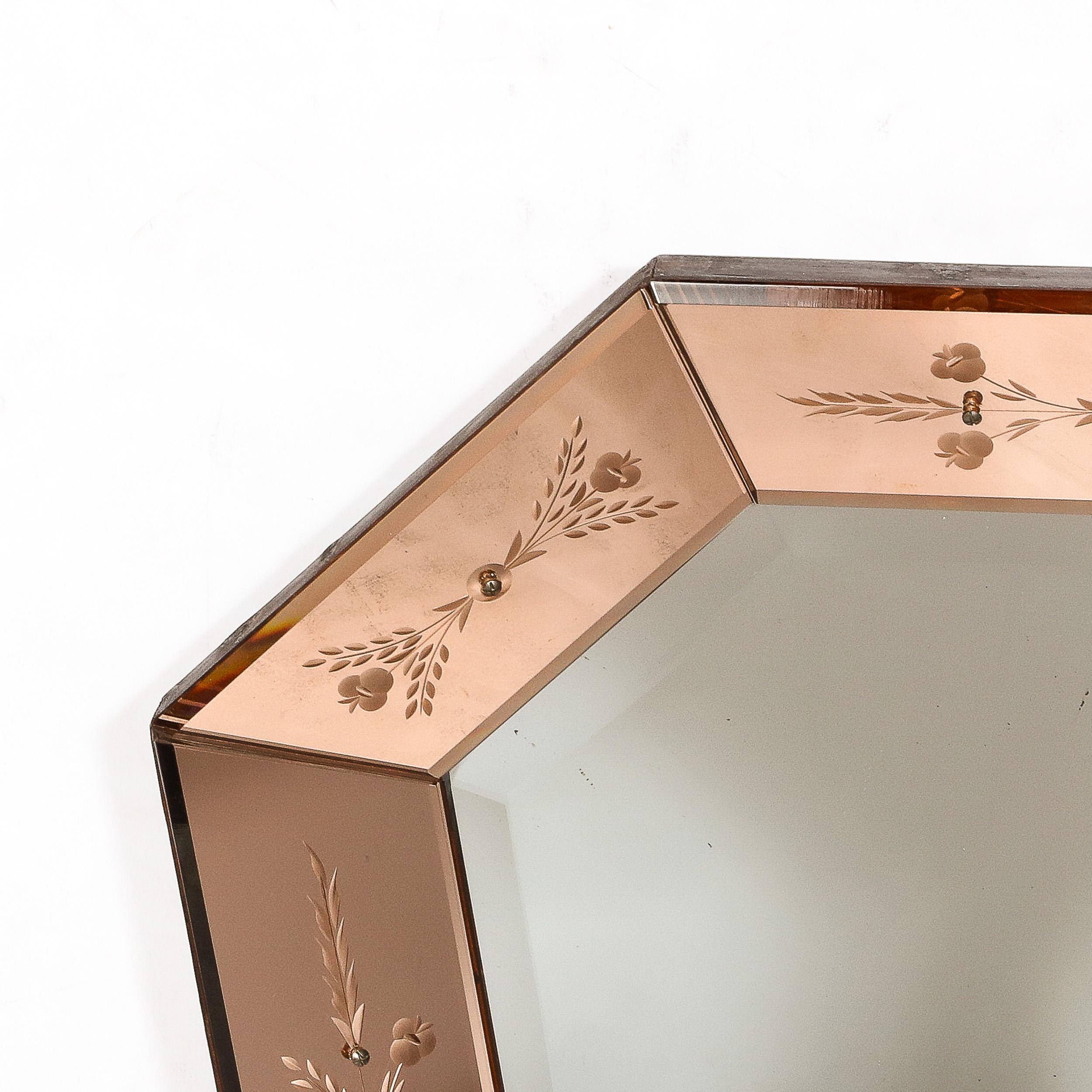 This beautiful Mid-Century Modernist Shadowbox Mirror in Smoked Rose originates from Italy, Circa 1950. Featuring a shield form octagonal border in a wide band of inward facing smoked rose glass with elegant reversed etched detailing precisely