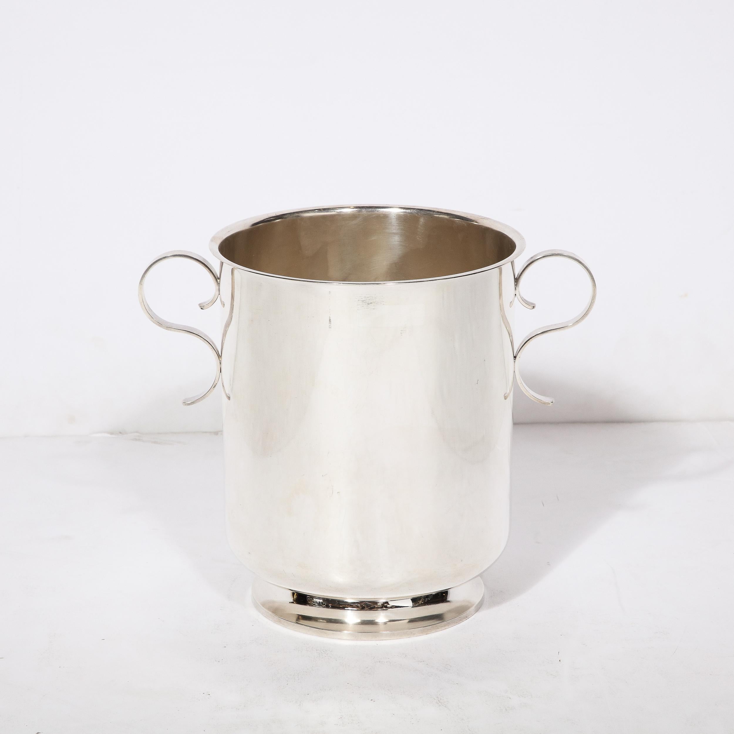 This lovely Mid-Century Modernist Silver plate Ice Bucket originates from France, Circa 1950. Featuring a sleek profile with minimal Scroll form handles on either side, the graceful curvatures create a timeless silhouette and accent with reference