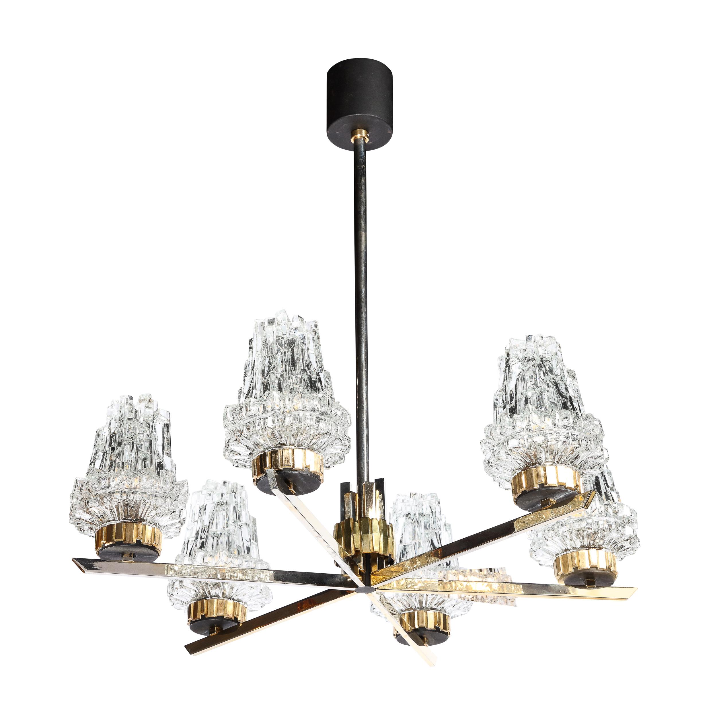 This highly unique and materially dynamic Mid-Century Modernist Chandelier with Cubist Glass Shades and Crennelated Brass Fittings originates from Italy, Circa 1960. With cohesive design elements and repeated geometric motifs throughout the piece,