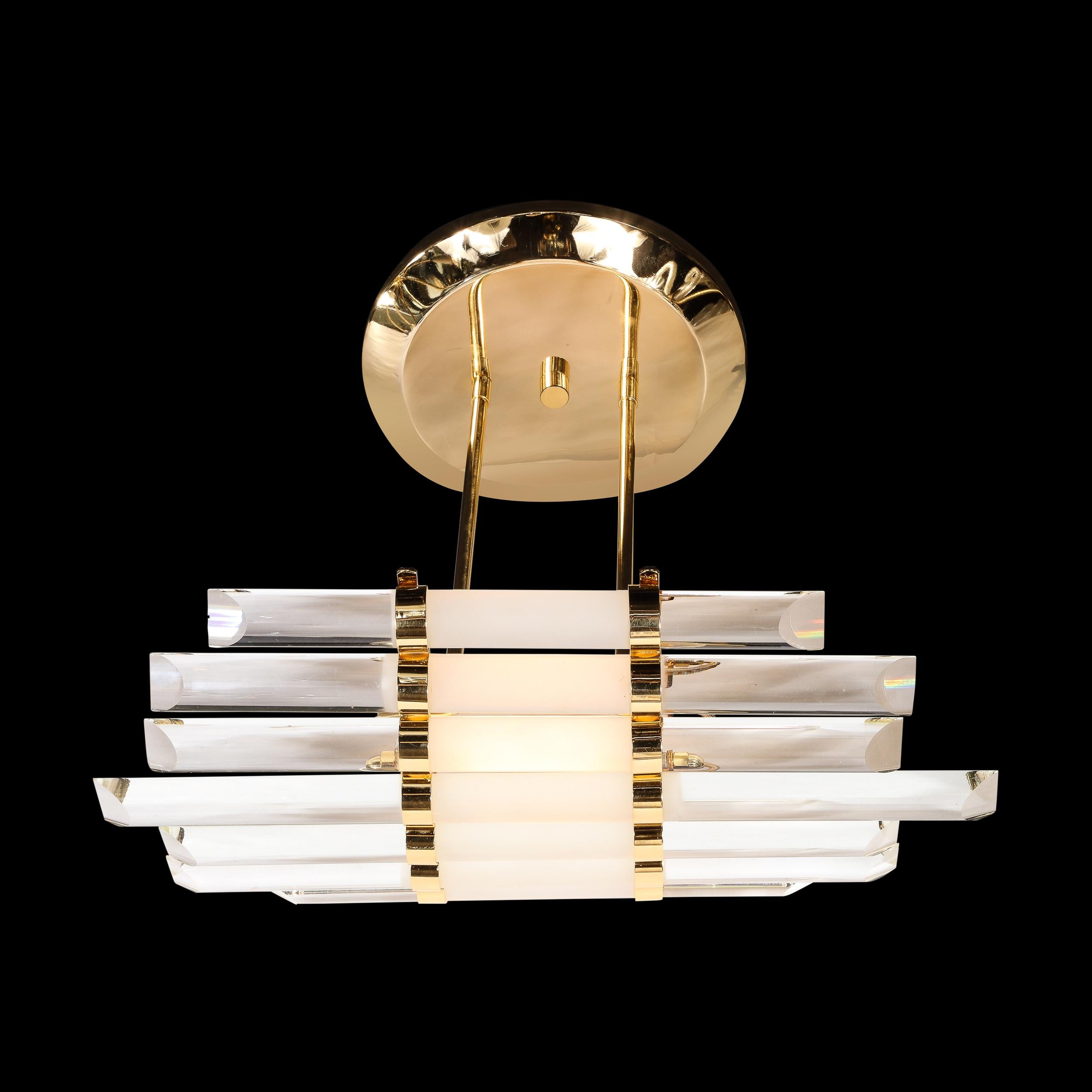 Mid-Century Modernist skyscraper style glass rod chandelier with brass fittings. This skyscraper style chandelier features a total of seven clear and frosted glass rods that are banded together in a curved form with brass fittings. It has been newly