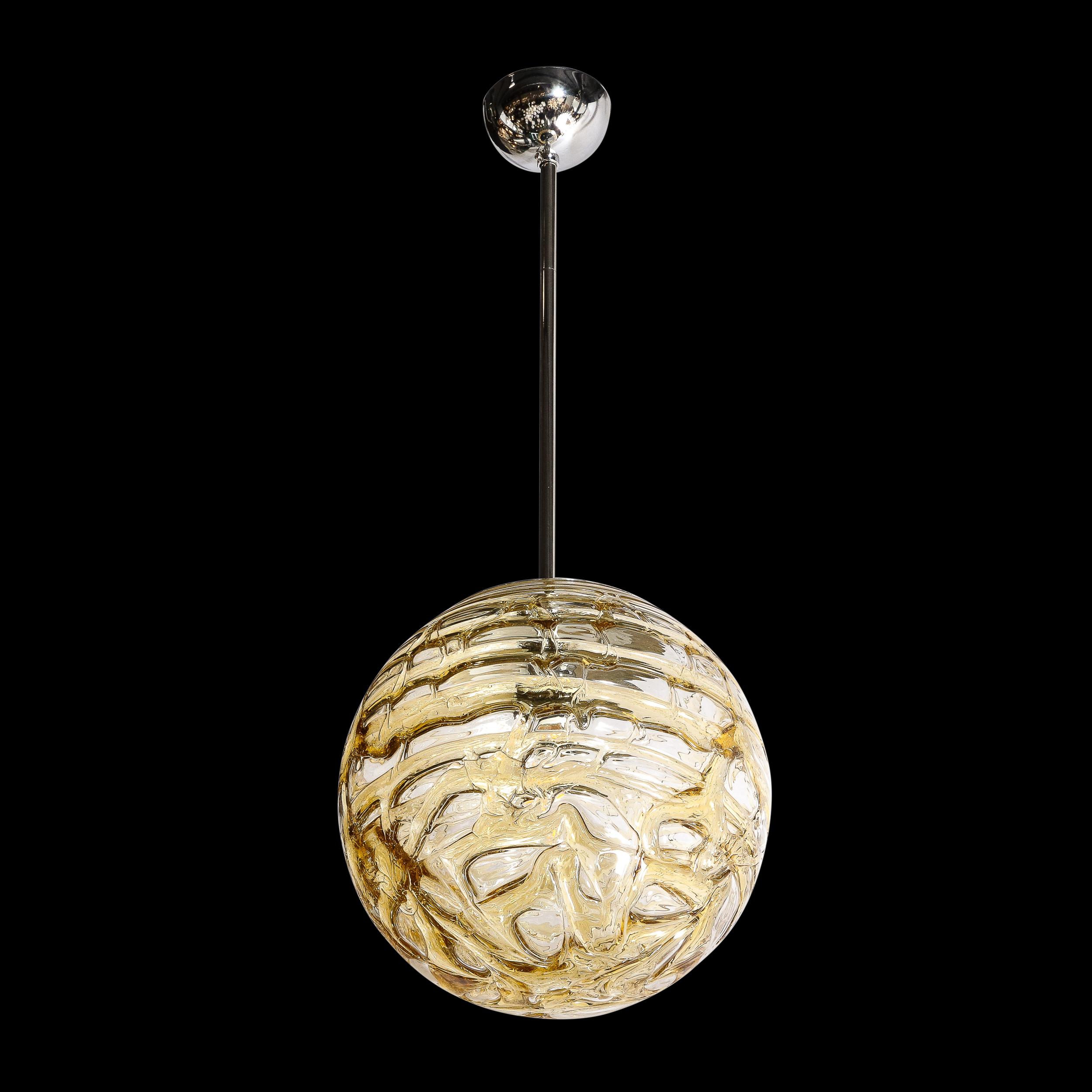 Ce lustre pendentif en verre soufflé à la main du milieu du siècle par Mazzega provient de Murano, Italie, vers 1970. Rendues dans une belle teinte de verre ambré fumé, de subtiles rainures se déplacent à travers la surface et se fondent les unes