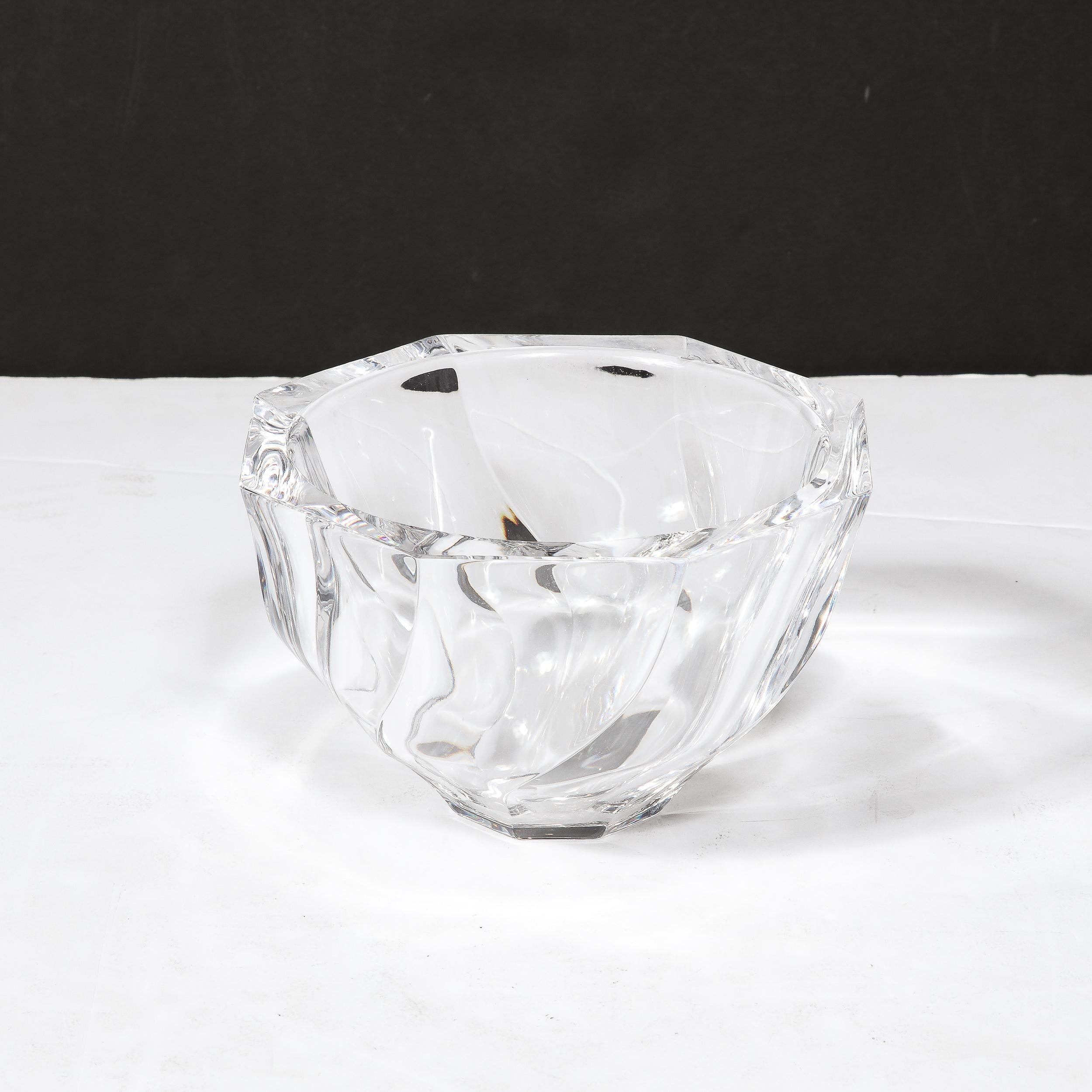 This Mid-Century Modernist Spiral Form crystal Bowl by Orrefors originates from Sweden, Circa 1950. Featuring an elegant and gently twisted composition rising from the modest octagonal base, the sides bend inward to form striking edges curving