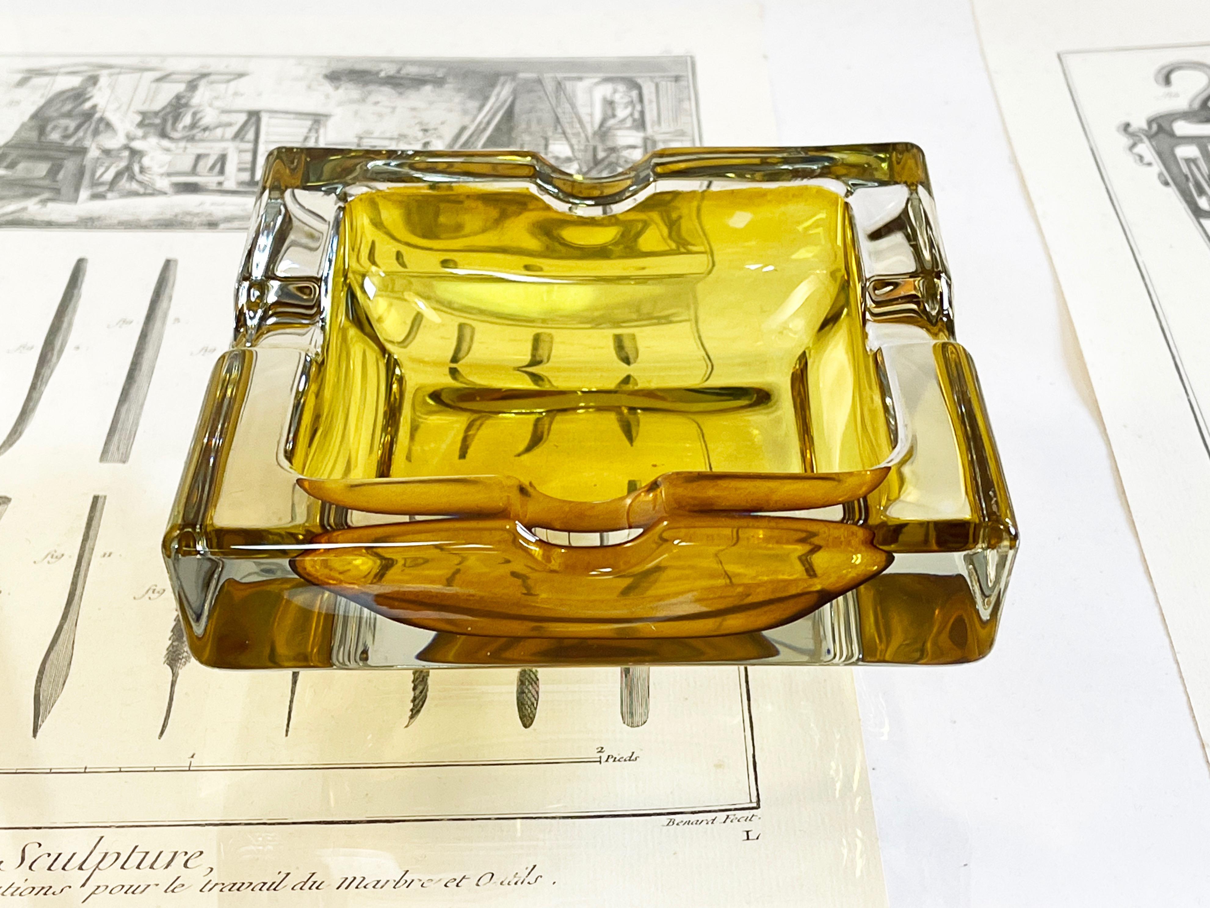 Posacenere vintage quadrato, bello e robusto, con sfumature dorate e ambrate.
Realizzato negli anni '70 da Walther Glass in Germania, interpretando lo stile Sommerso degli artisti di metà secolo.