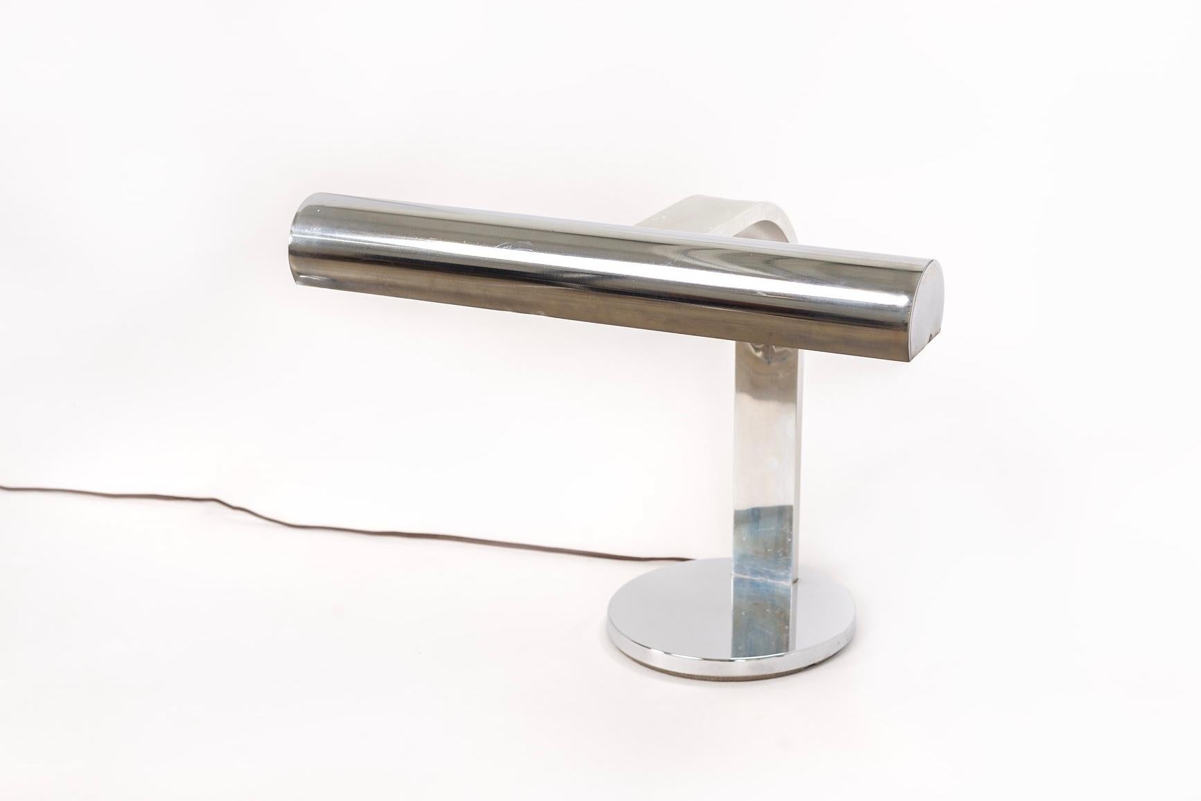 This unique vintage midcentury table lamp is circa 1970. The clean modernist design features a long cylindrical steel shade on an arcing flat bar arm with a heavy round base. Original felt bottom protects surfaces.