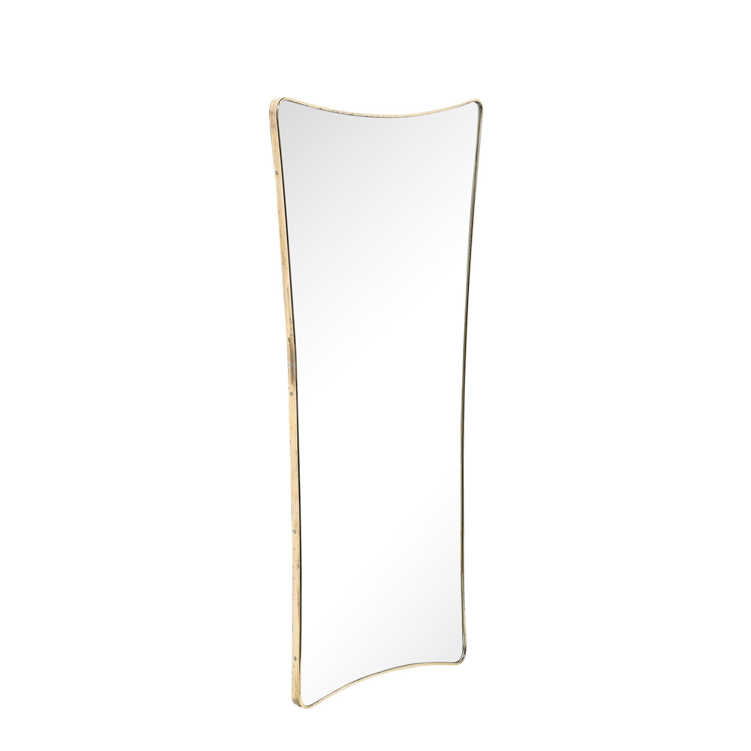 This dynamic and striking Mid-Century Modernist Tapered Atomic Form Brass Wrapped Mirror originates from Italy, Circa 1960. Features a distinct tapered form composed of swooping curves and carefully rounded corners, the edge of the mirror is