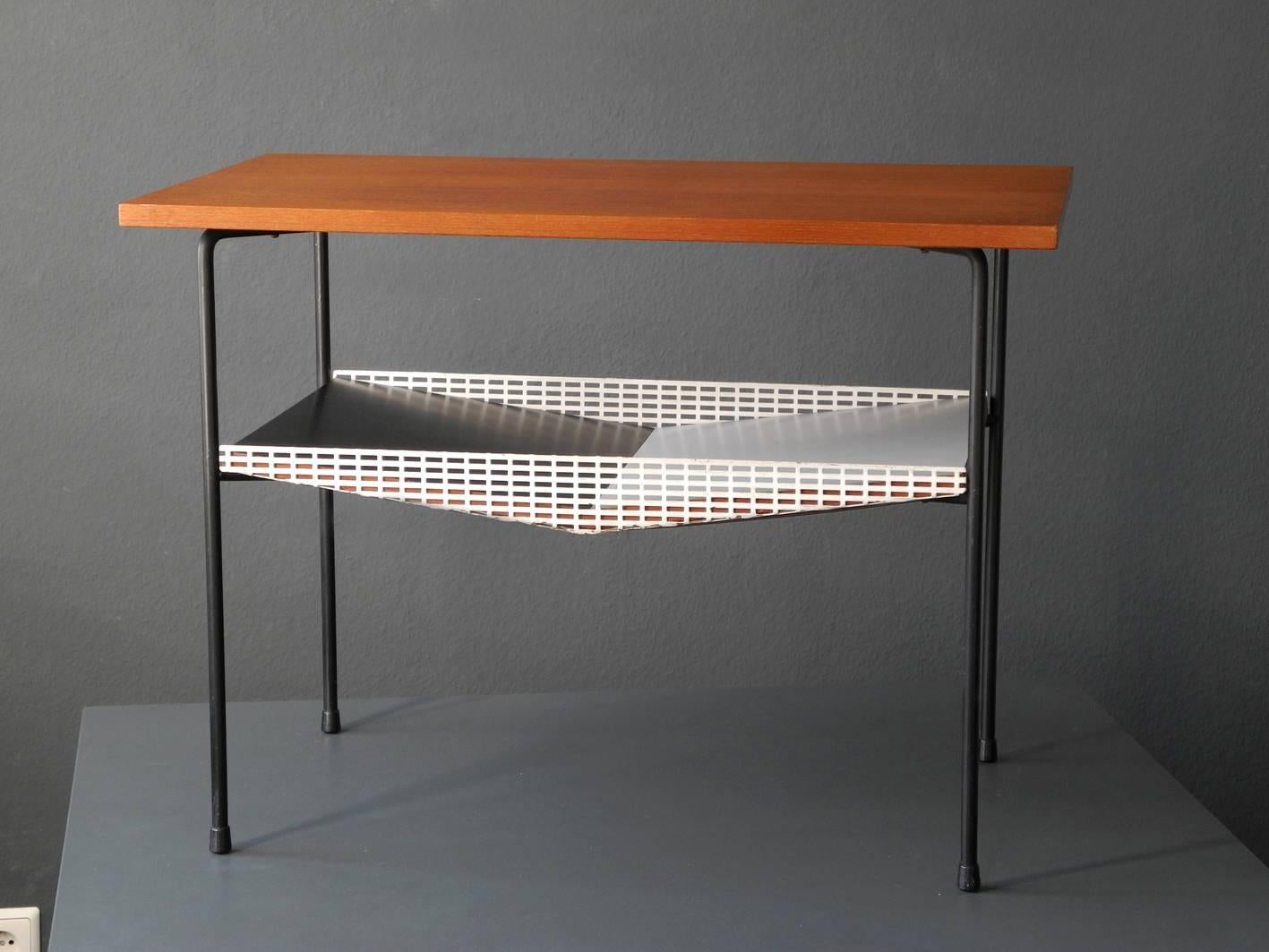 Very rare exceptional Mid-Century Modernist side table.
Great minimalistic and rare design.
Upper tabletop made of solid wood with teak veneer and lower shelf made of pressed wood coated with black-white resopal.
Sides made of perforated sheet