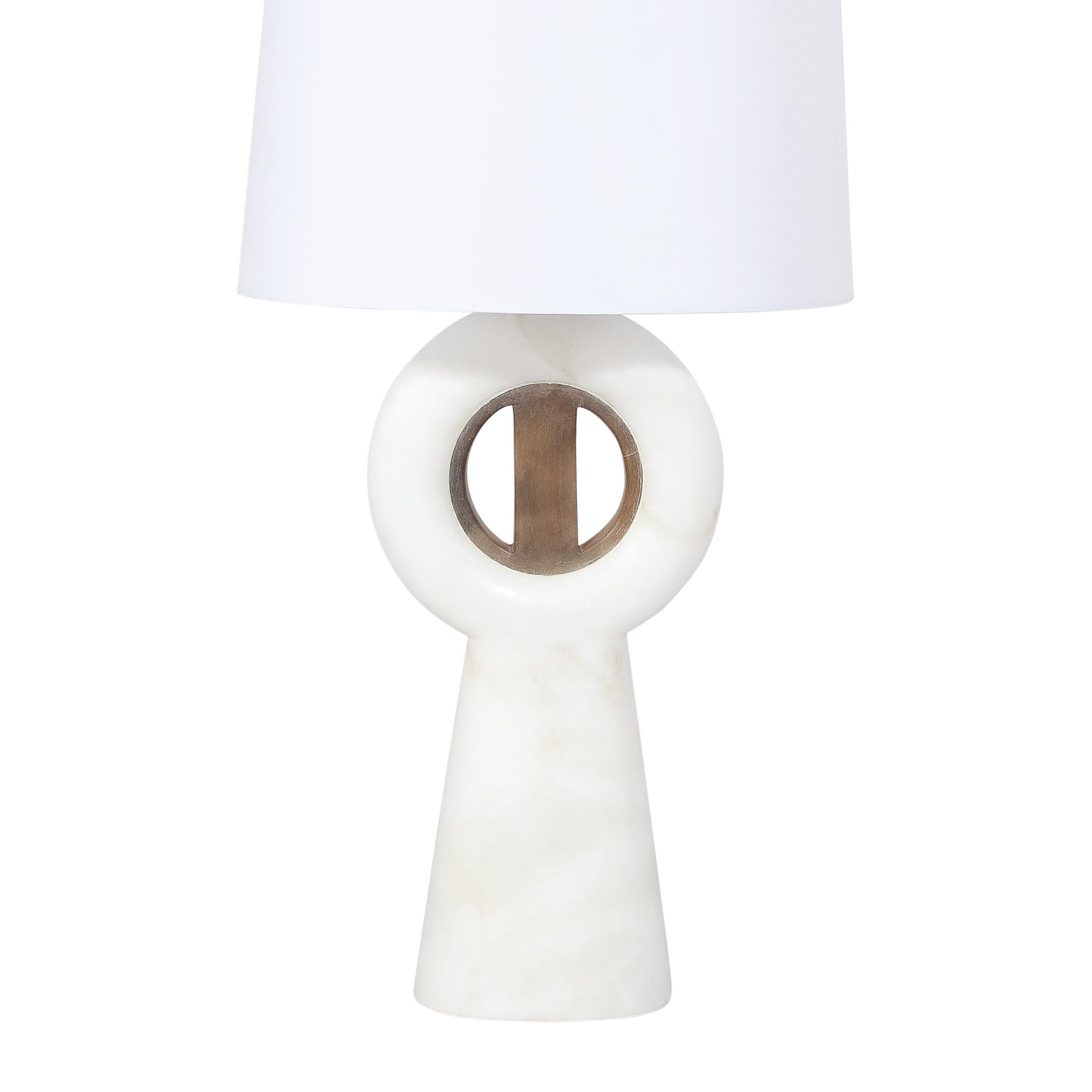 This stunning and graphic modernist TOTEM lamp was realized in Italy during the latter half of the 20th century. It features a tapered conical alabaster body that flares at its top to a circular form of the Material. An onyx medallion consisting of